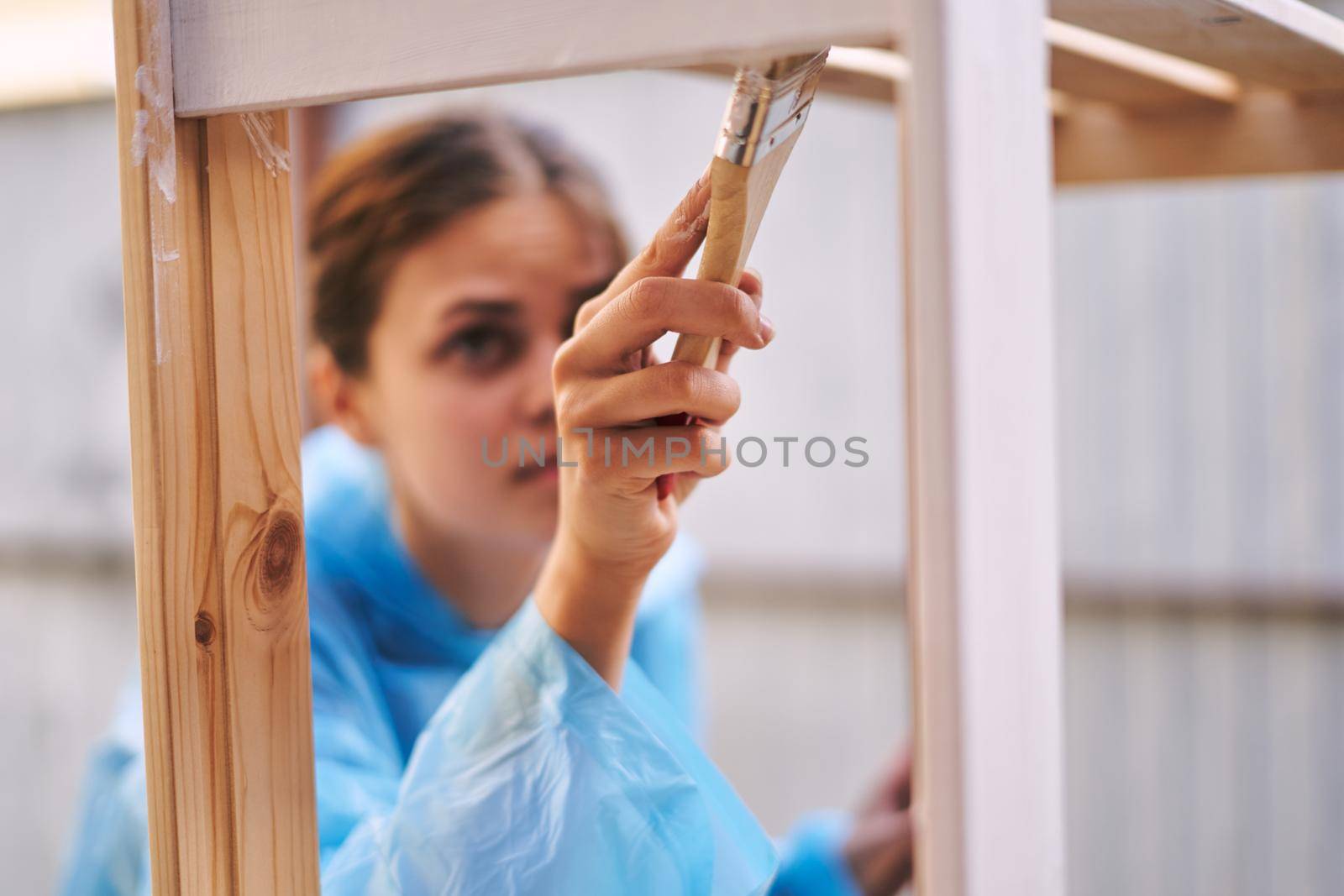 woman in protective suit painting wood renovation design. High quality photo