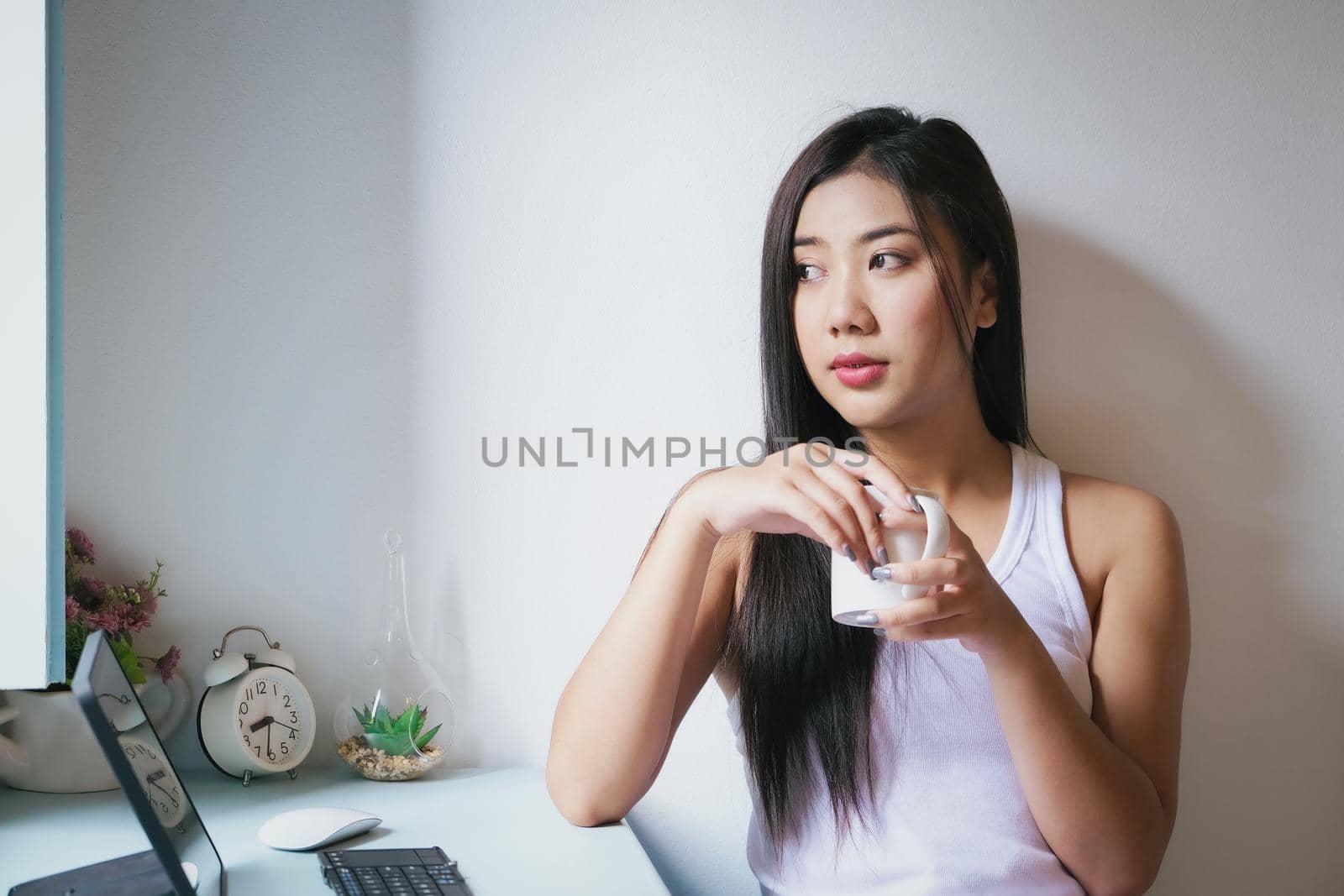 new normal, a businesswoman using tablet to work for a company Via the internet on your desk at home. by Manastrong