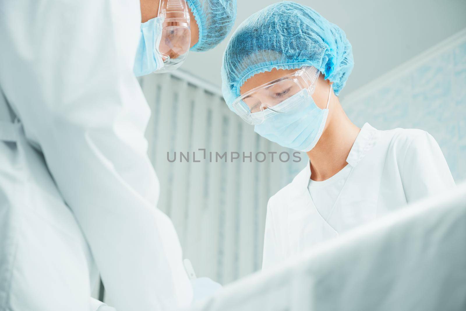 Male and female serious surgeons are working in operating room, teamwork