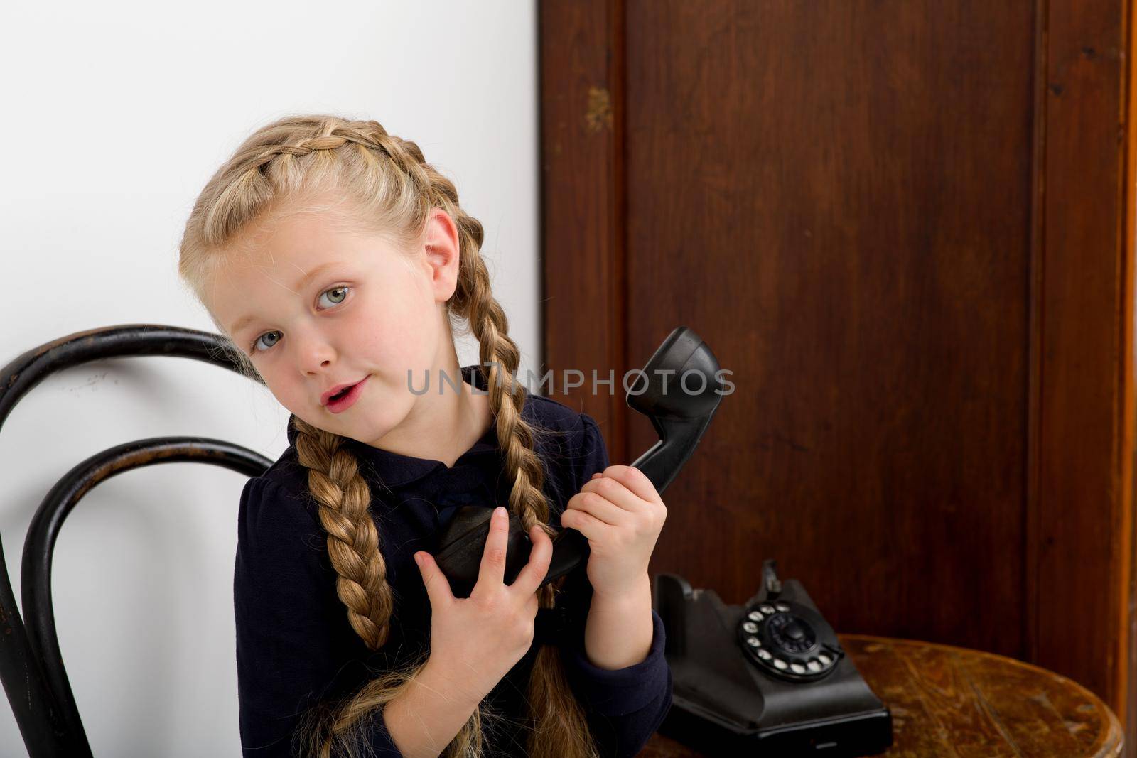 Blonde girl talking by old black phone by kolesnikov_studio