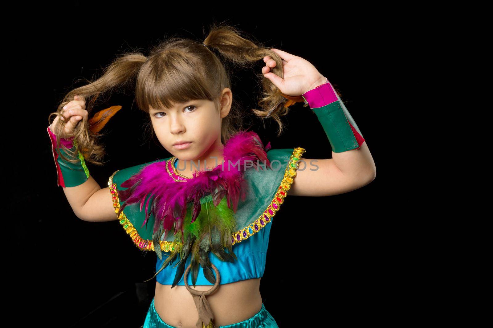 Portrait of girl with angry face expression. Beautiful preteen girl dressed colorful ethnic costume standing against black background. Child with serious face expression posing in studio