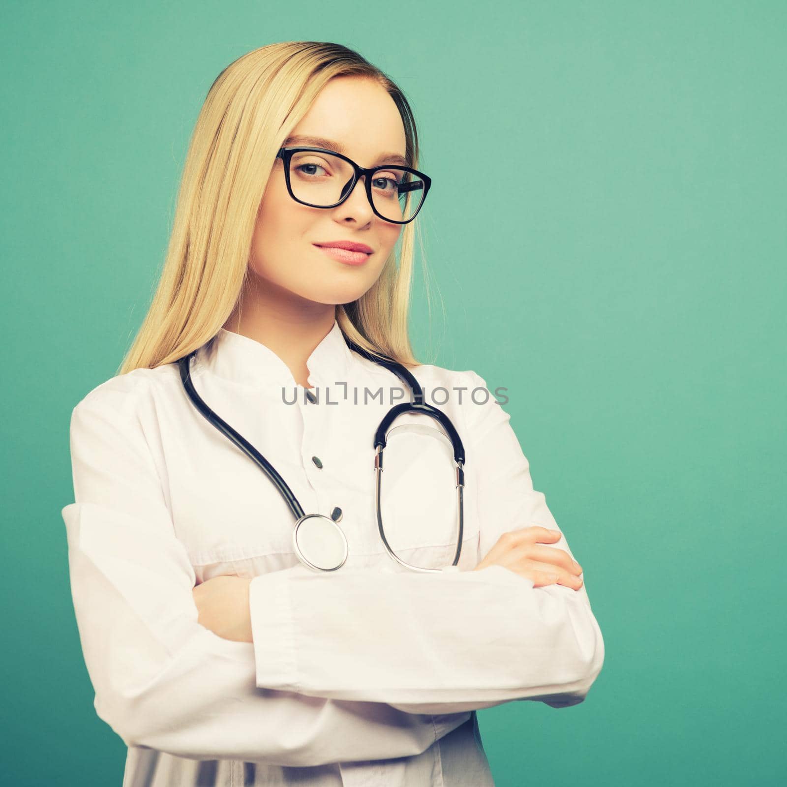 Smiling young medical doctor woman with stethoscope. Isolated over blue background. toned