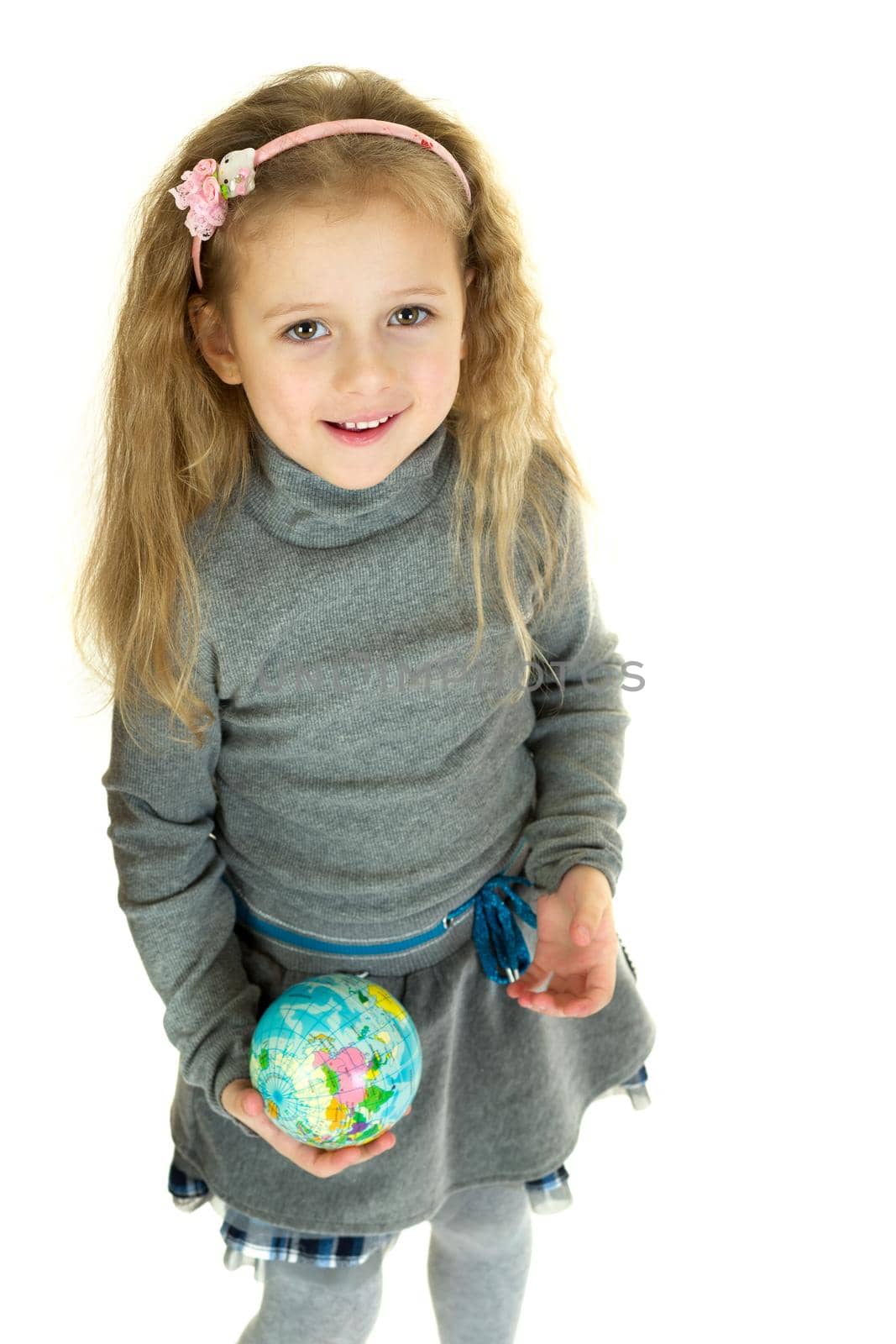 Cute girl holding small globe in her hands. Lovely girl elementary school student studying geography with globe. Cute kid wearing casual clothes posing against white background