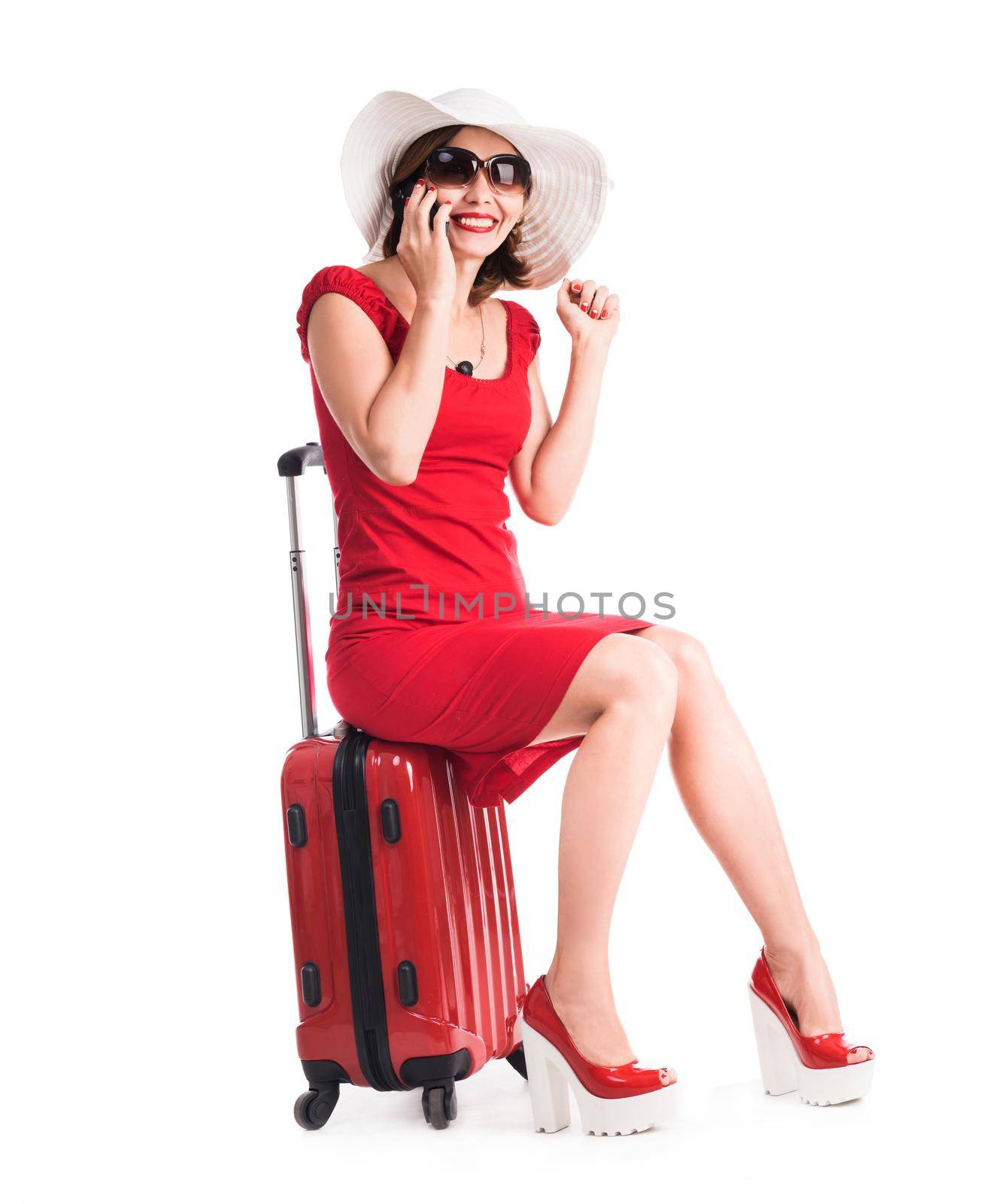 girl sitting on a suitcase and talking on a phone