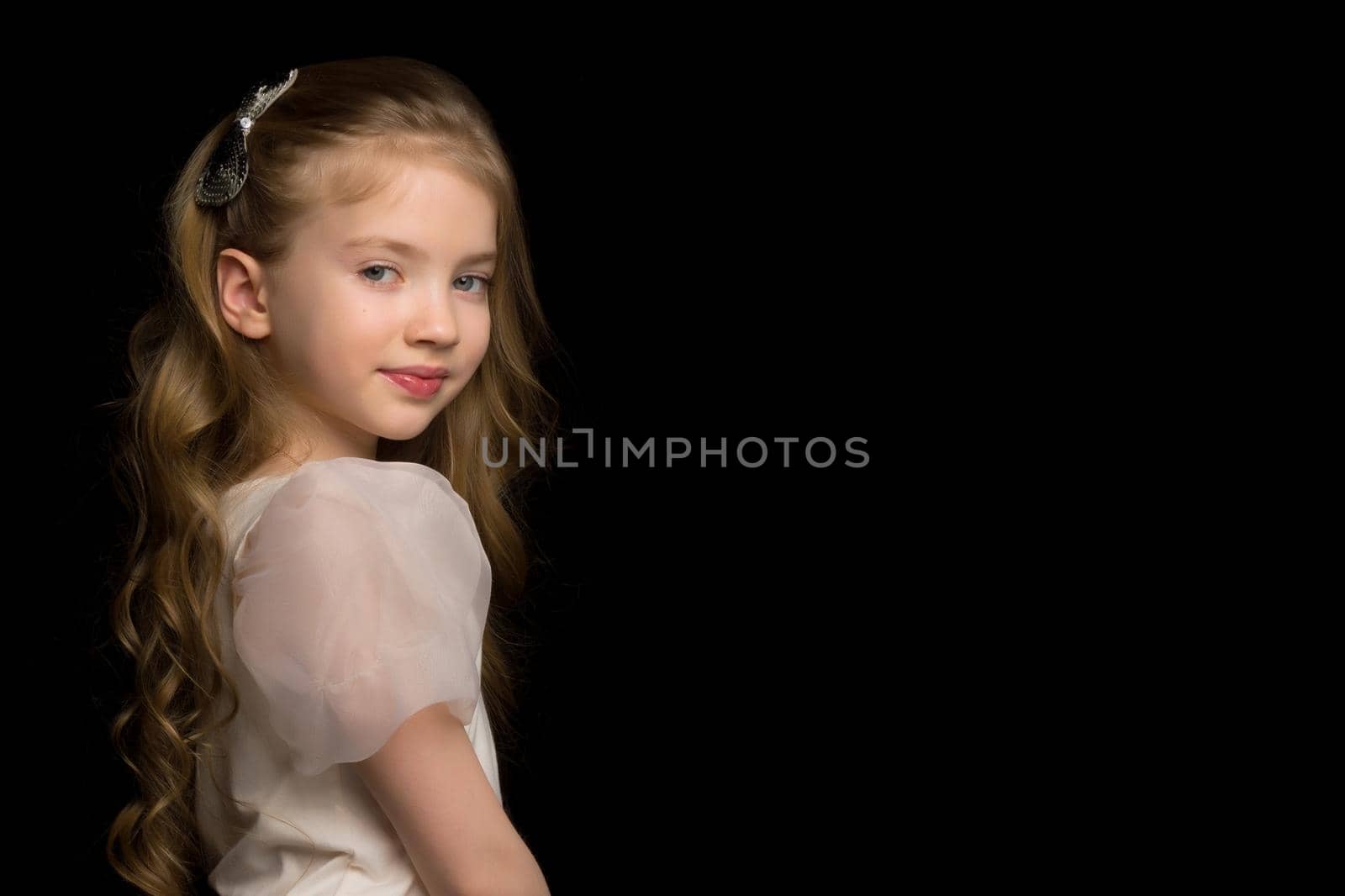 Beautiful little girl on a black background. Studio photography.Close-up.