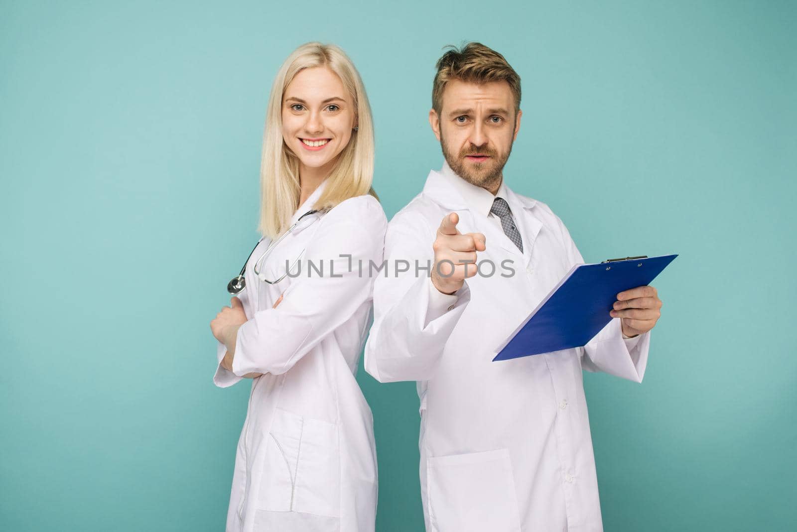Happy medical team of doctors, man pointing to camera and smiling woman by zartarn
