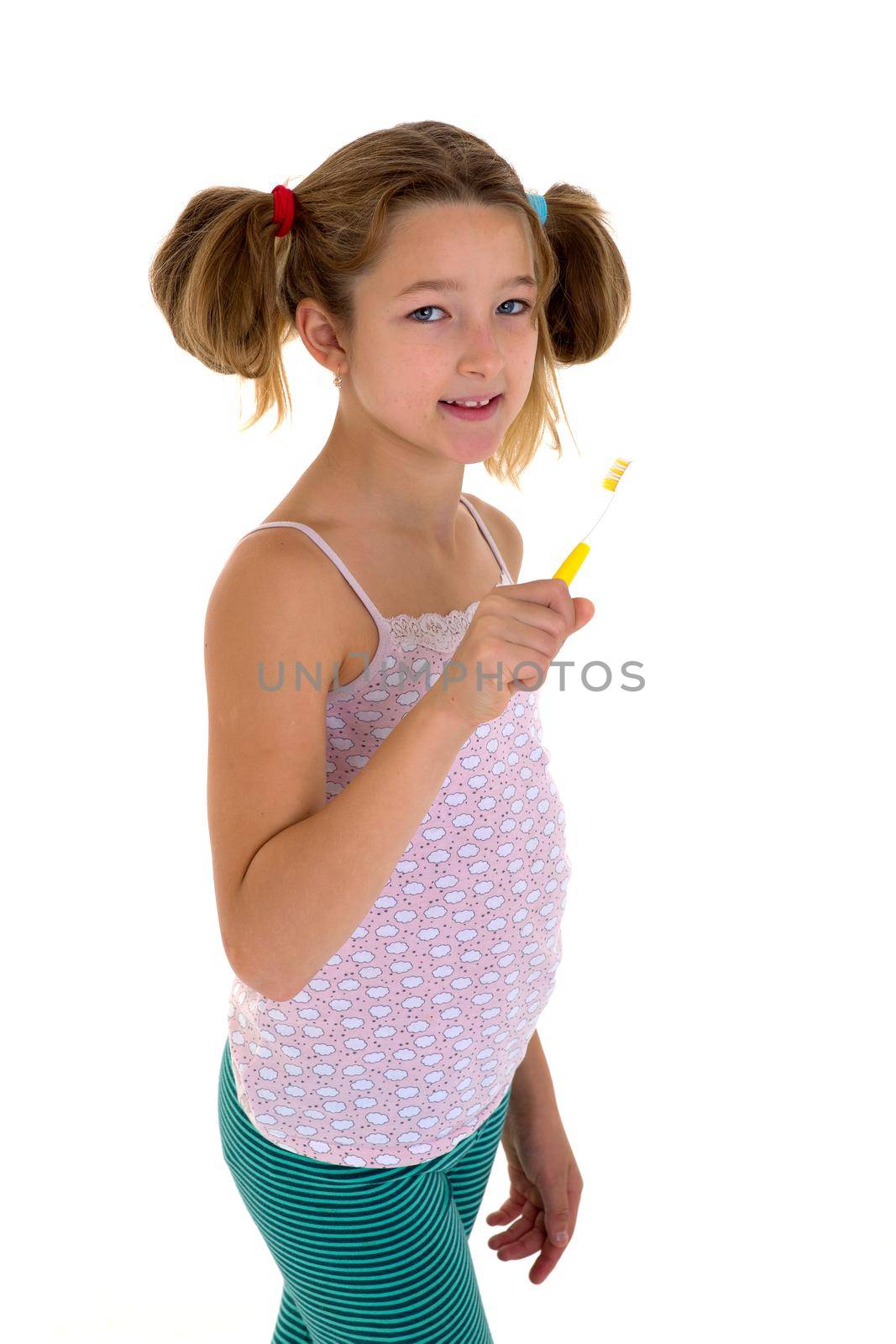 Smiling girl standing with toothbrush in her hands. Preteen girl brushing her teeth before or after sleeping. Cute child daily routine concept