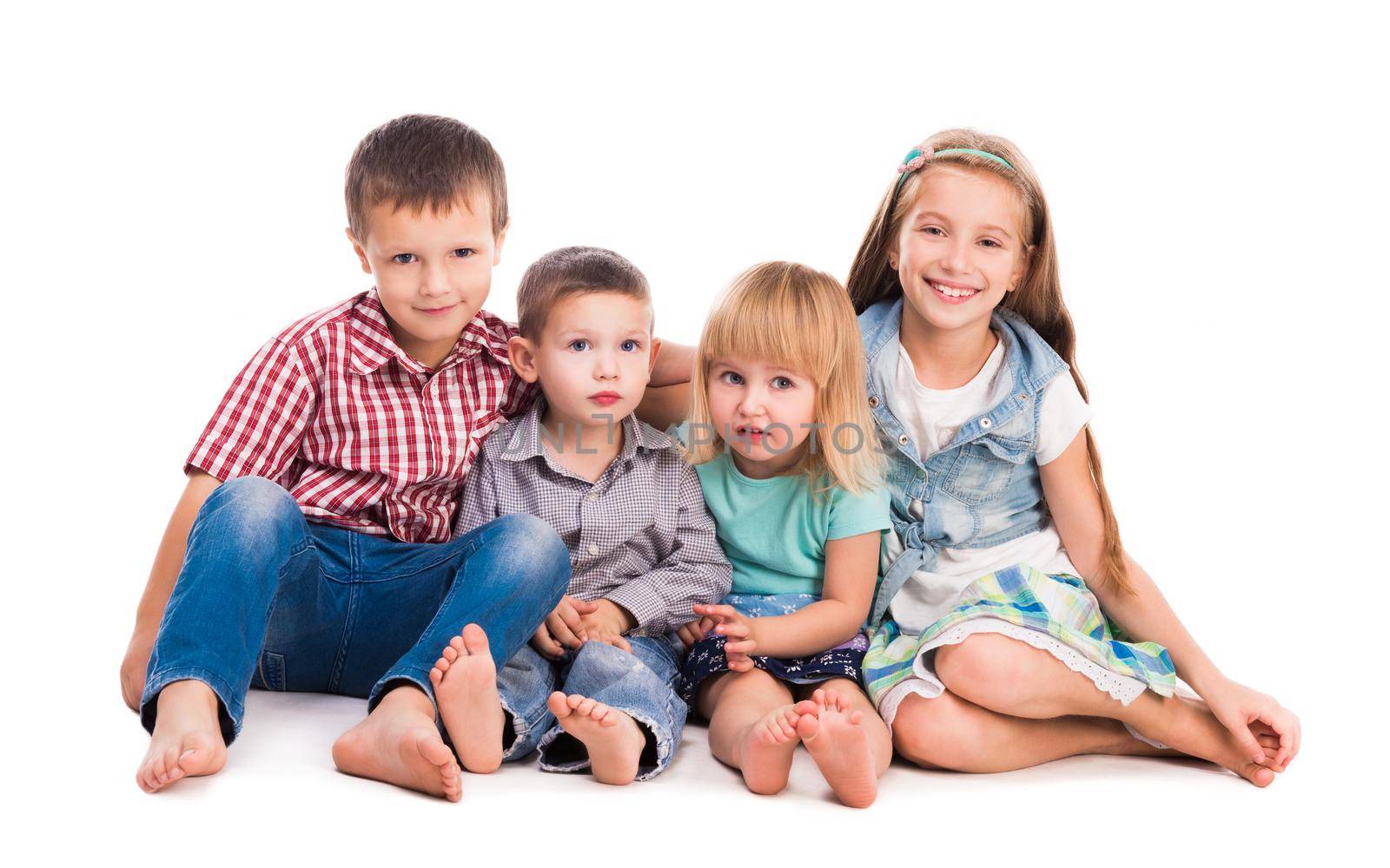 four cute children sitting on the floor isolated on white background