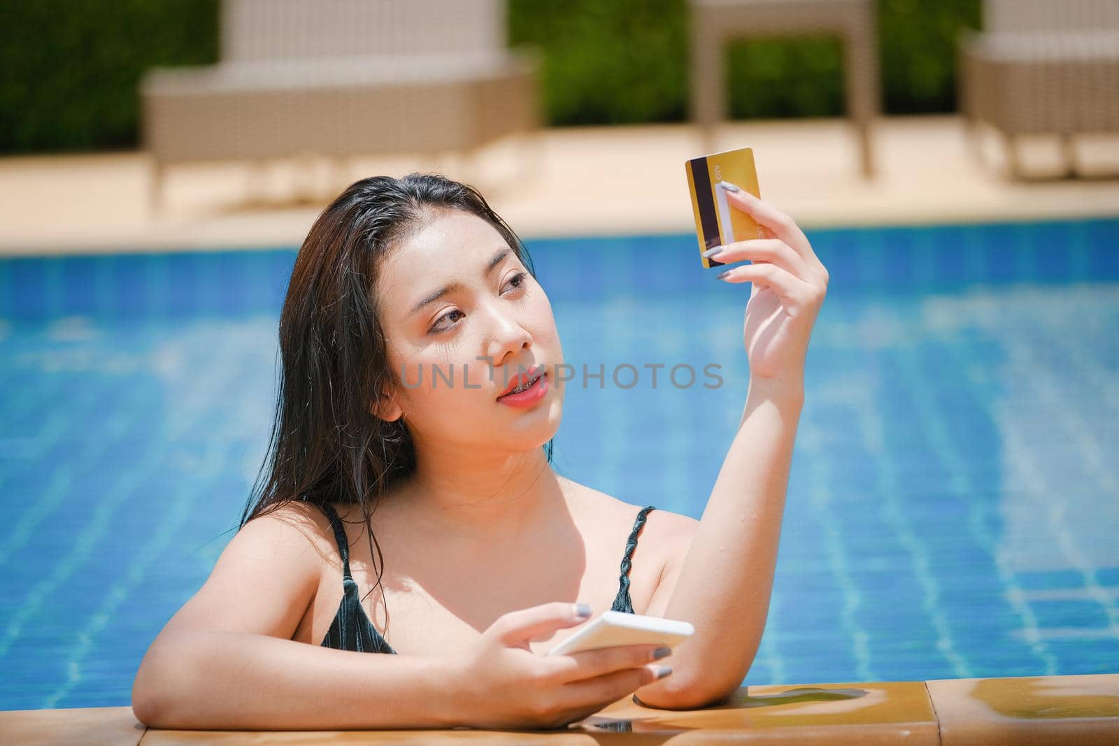 online payment, A teenage girl who swims is using her credit card with her phone to make purchases. online via internet