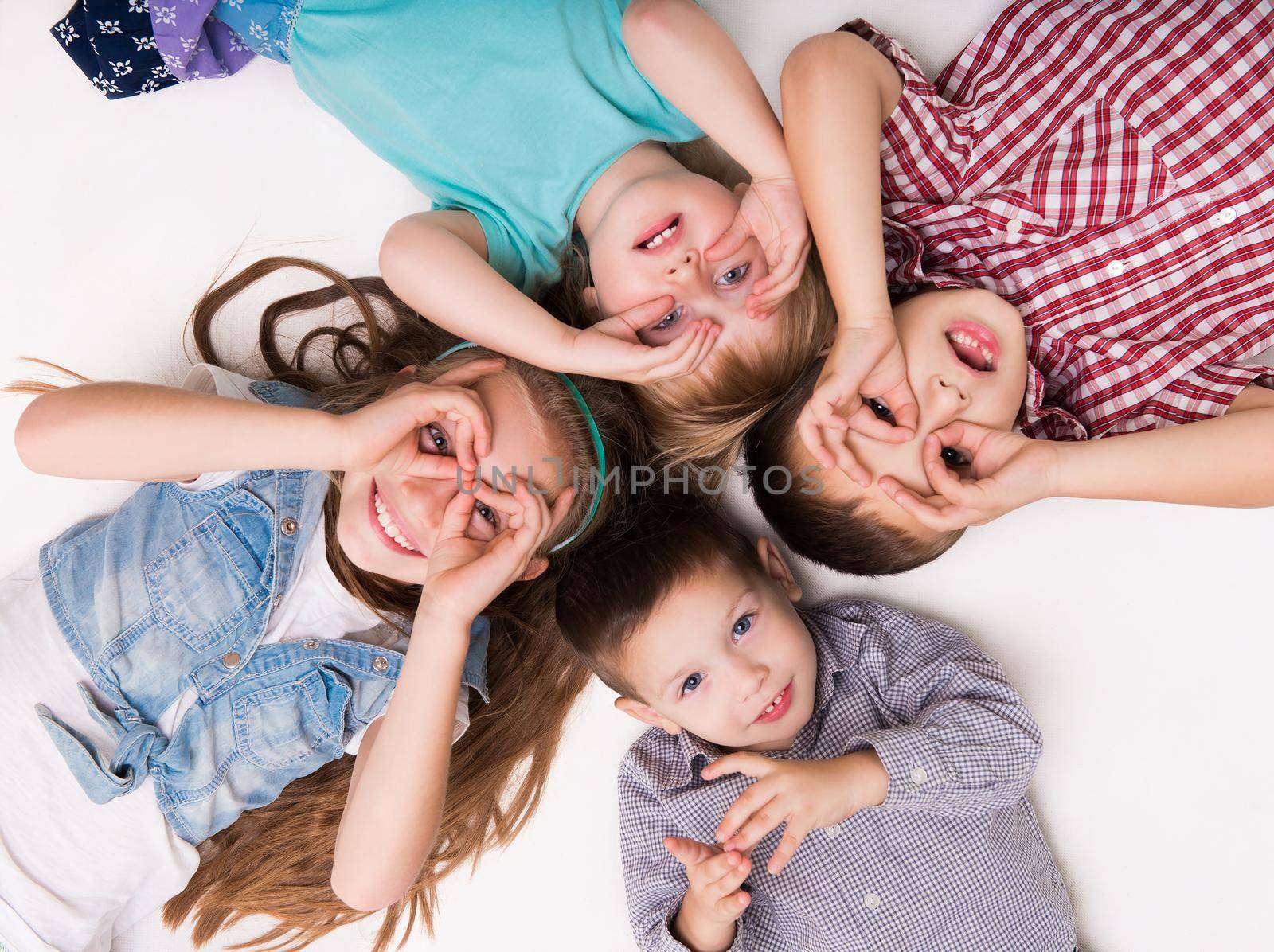 children lying on the floor with hands imitating glasses by GekaSkr