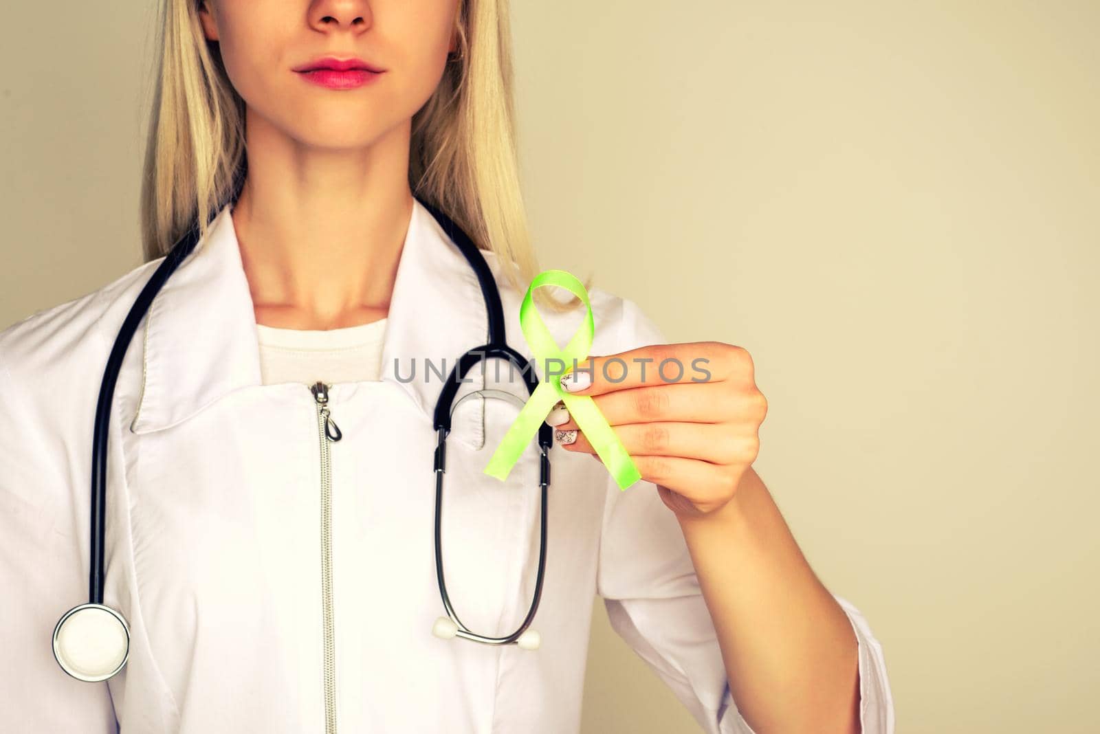 Female doctor in white uniform with light green ribbon awareness in hand for Celiac Disease, Chronic pelvic Pain, Human Papilloma Virus, Sexually Transmitted Diseases STD, Medical Healthcare concept - Image