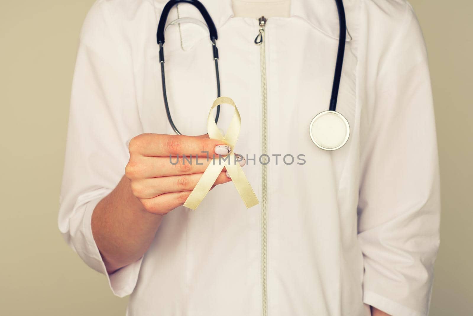 Yellow ribbon symbolic color for Sarcoma Bone cancer, Bladder health, Liver disease, Spina Bifida Awareness Month and suicide prevention in doctor's hand - Image