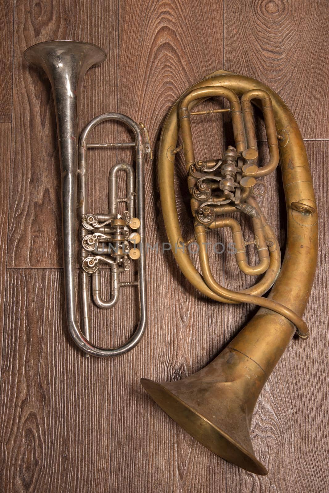 old brass wind instrument and horn on a wooden background. studio