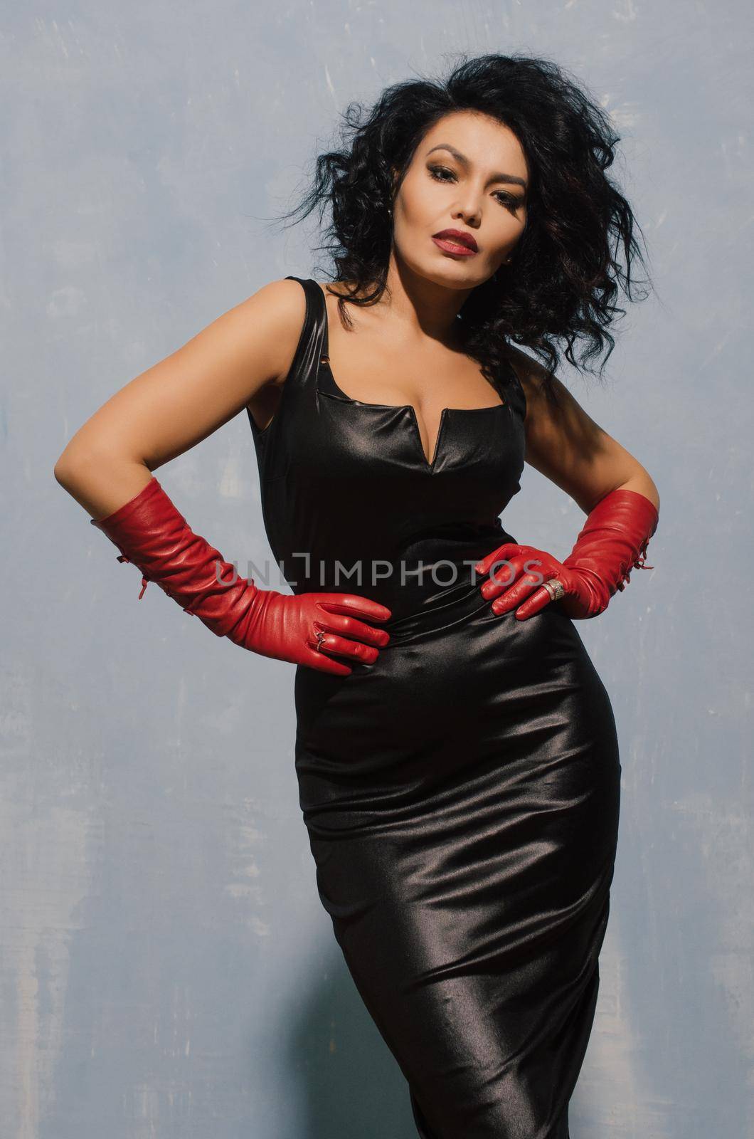 Luxurious Asian woman posing in black leather dress and red gloves. Dominant Fetish Lady. - image