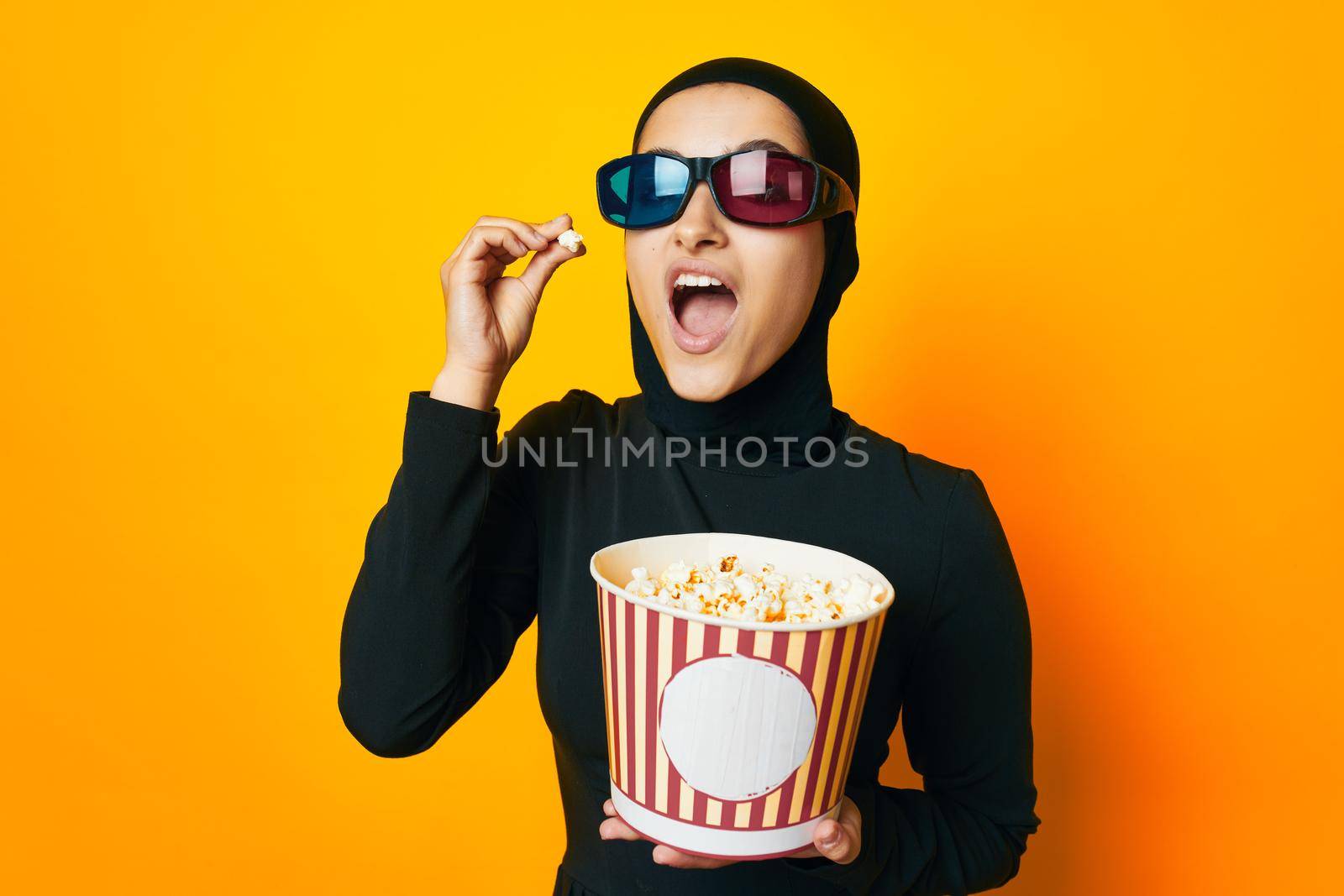 arab woman in black hijab popcorn 3D glasses cinema ethnicity model. High quality photo