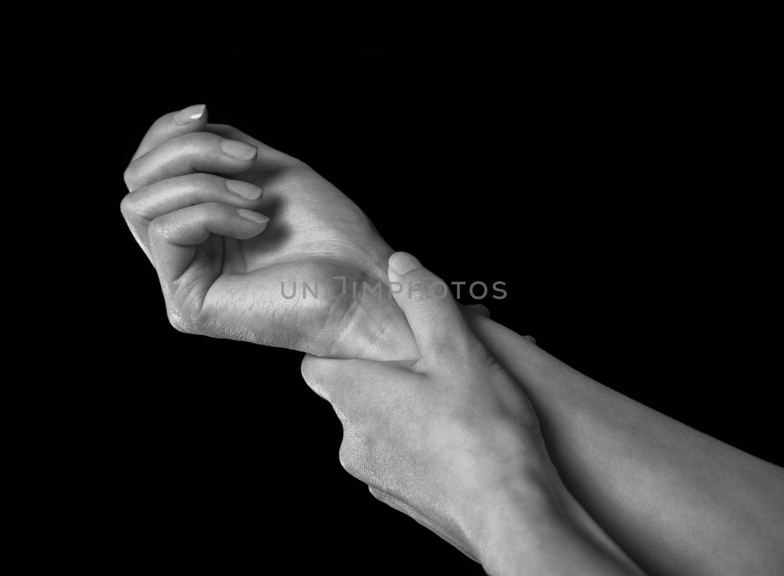Unrecognizable woman holds her hand, pain in the wrist, black and white image