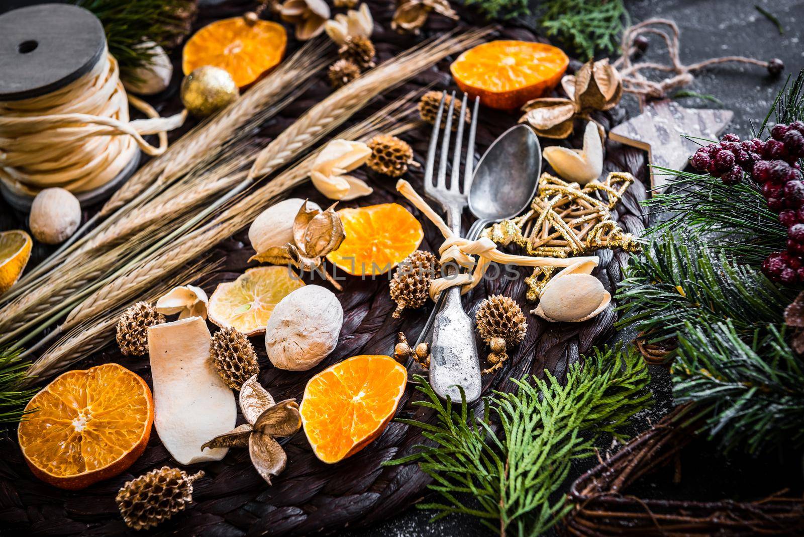fork and spoon with Christmas decorations on a black textured table