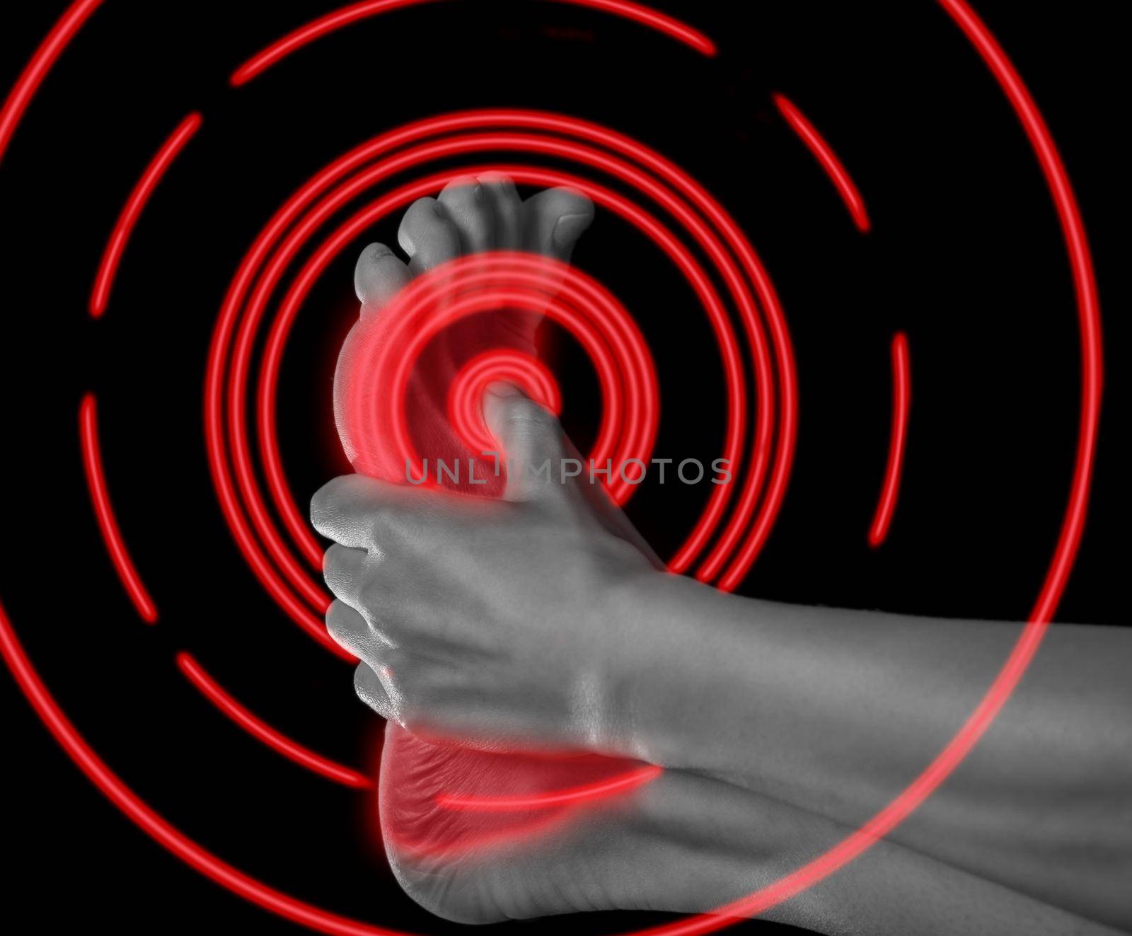 Woman holds her foot, pain in the foot, monochrome image, pain area of red color