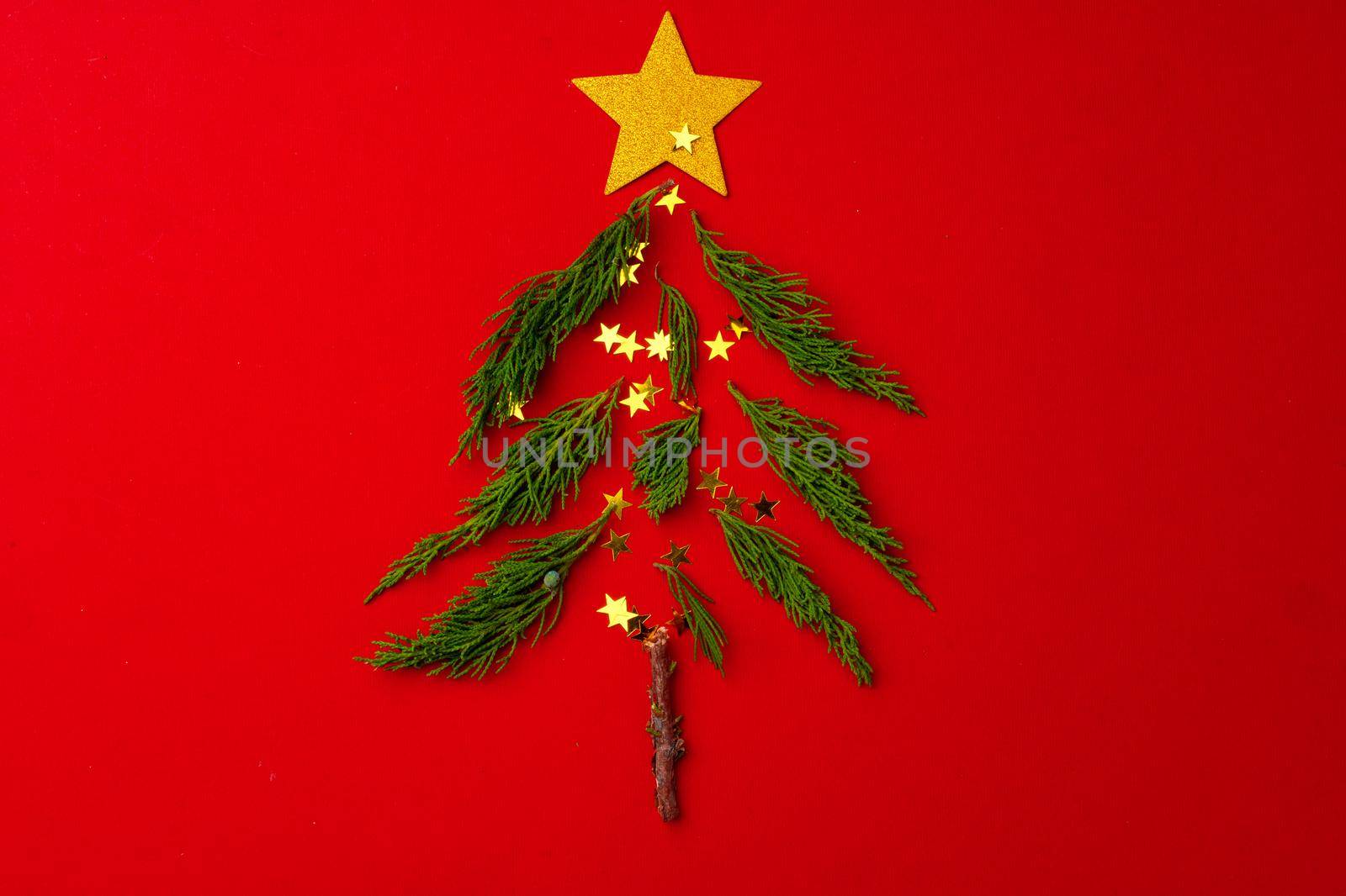 New year and Christmas background with fur tree branches on red background top view