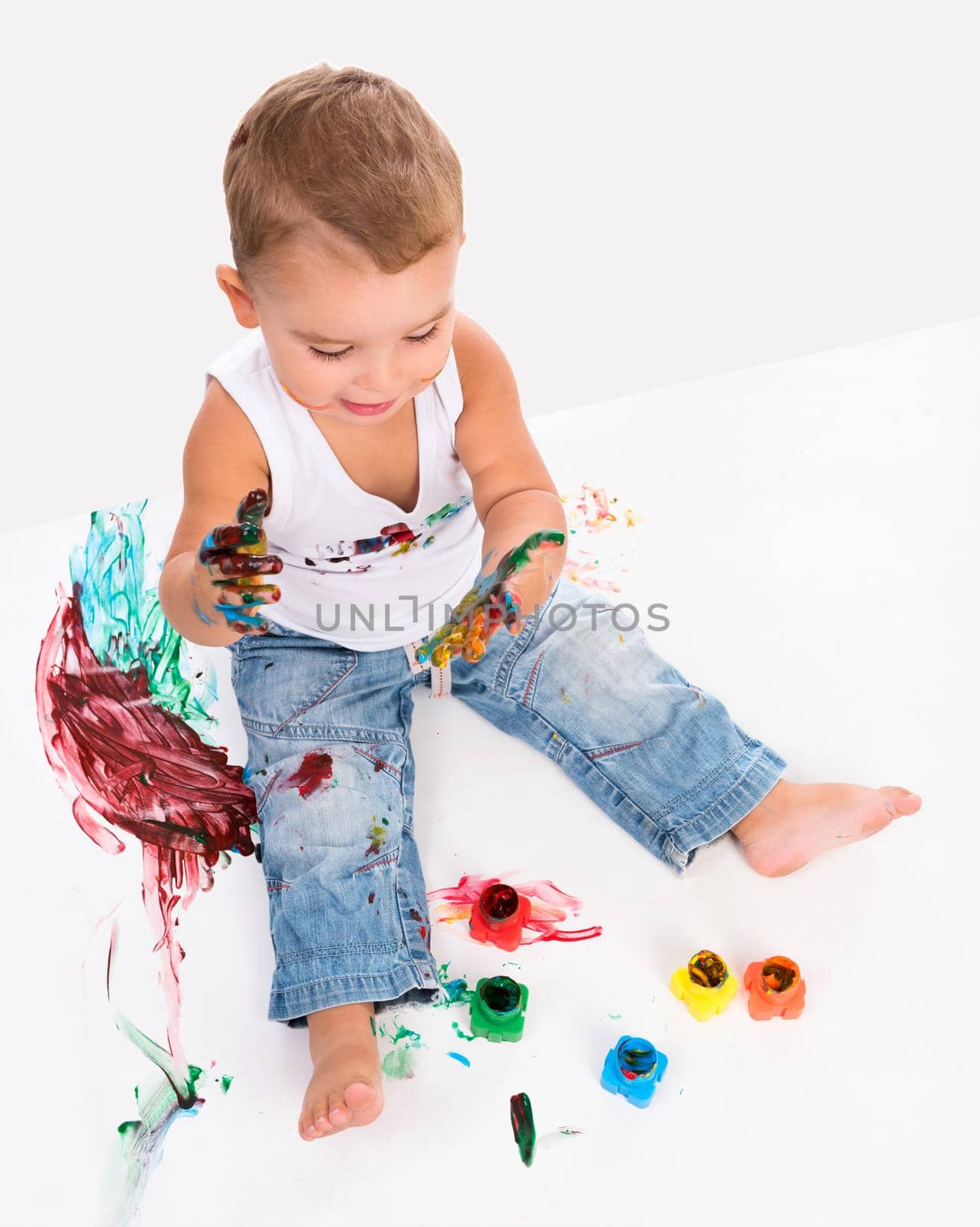 cute little boy painting his hands isolated on white background