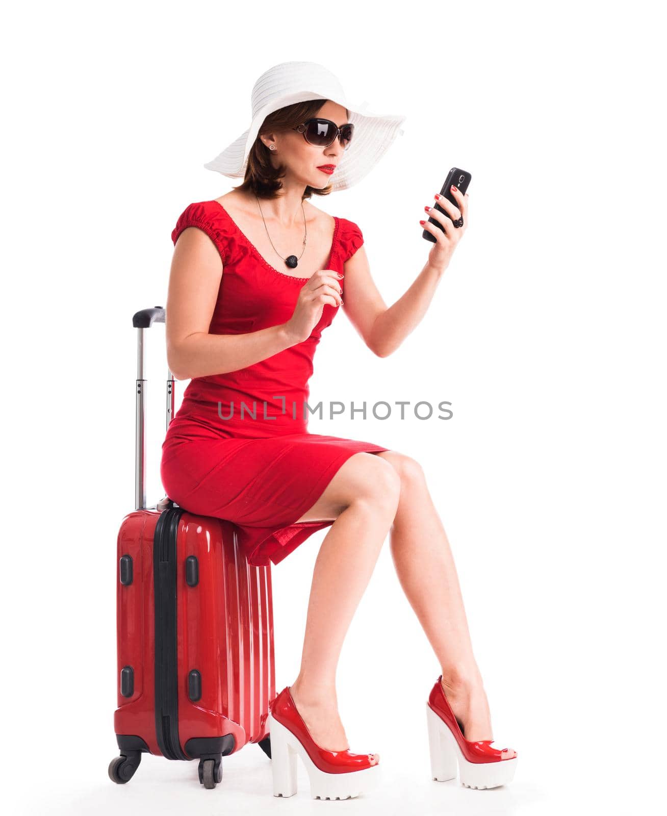 girl with telephone sitting on suitcase and going on vacation
