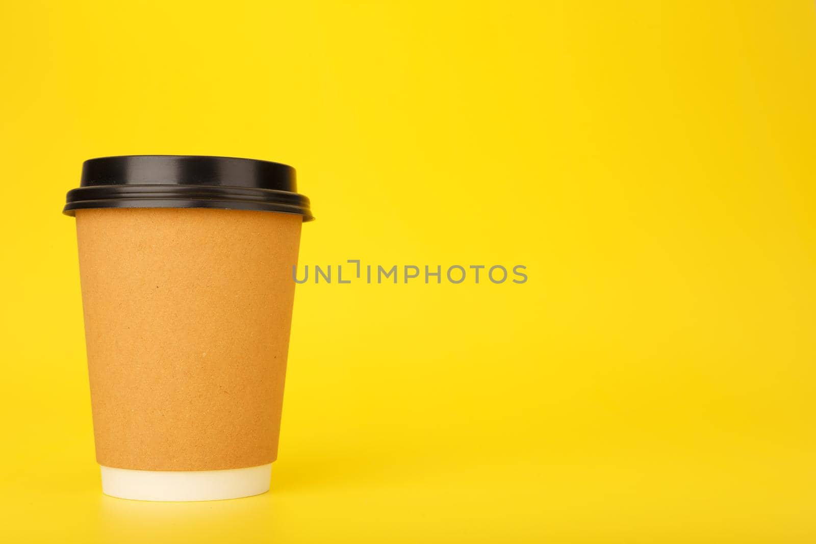 Minimal composition with brown cardboard cup of coffee on yellow background with copy space by Senorina_Irina