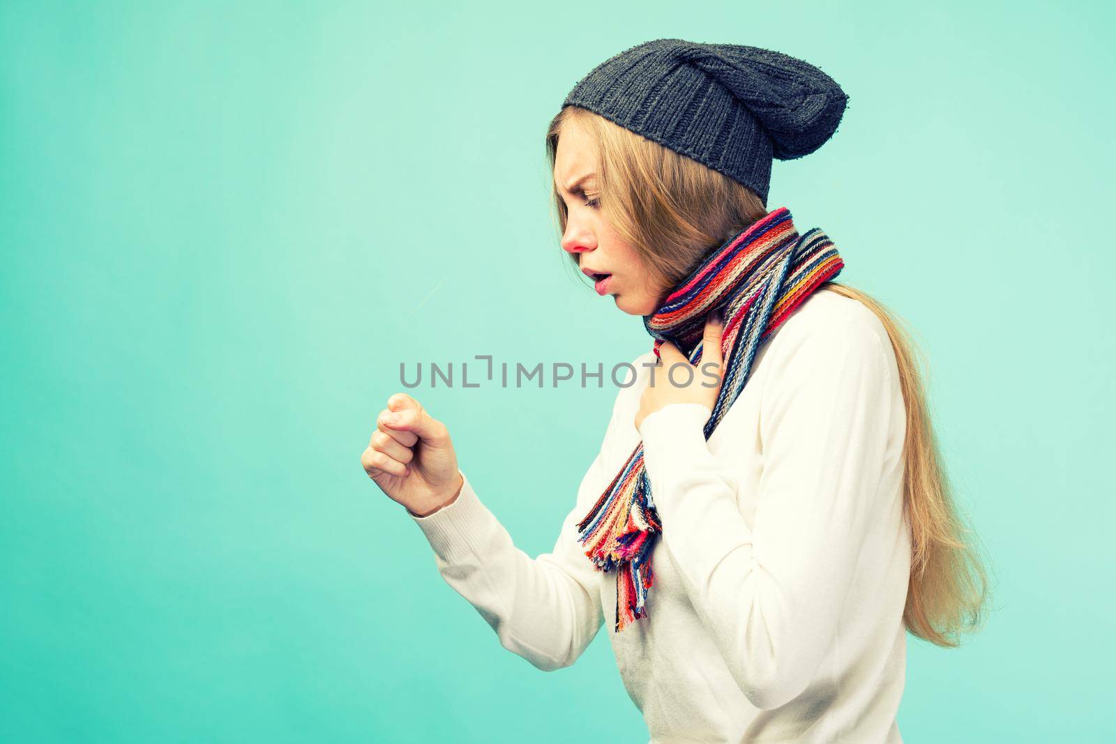 The girl has symptoms of coronavirus. Cold And Flu. Portrait Of Beautiful Teen Girl With Cough And Sore Throat Feeling Sick Indoors. Closeup Of Ill Unhealthy Woman Coughing