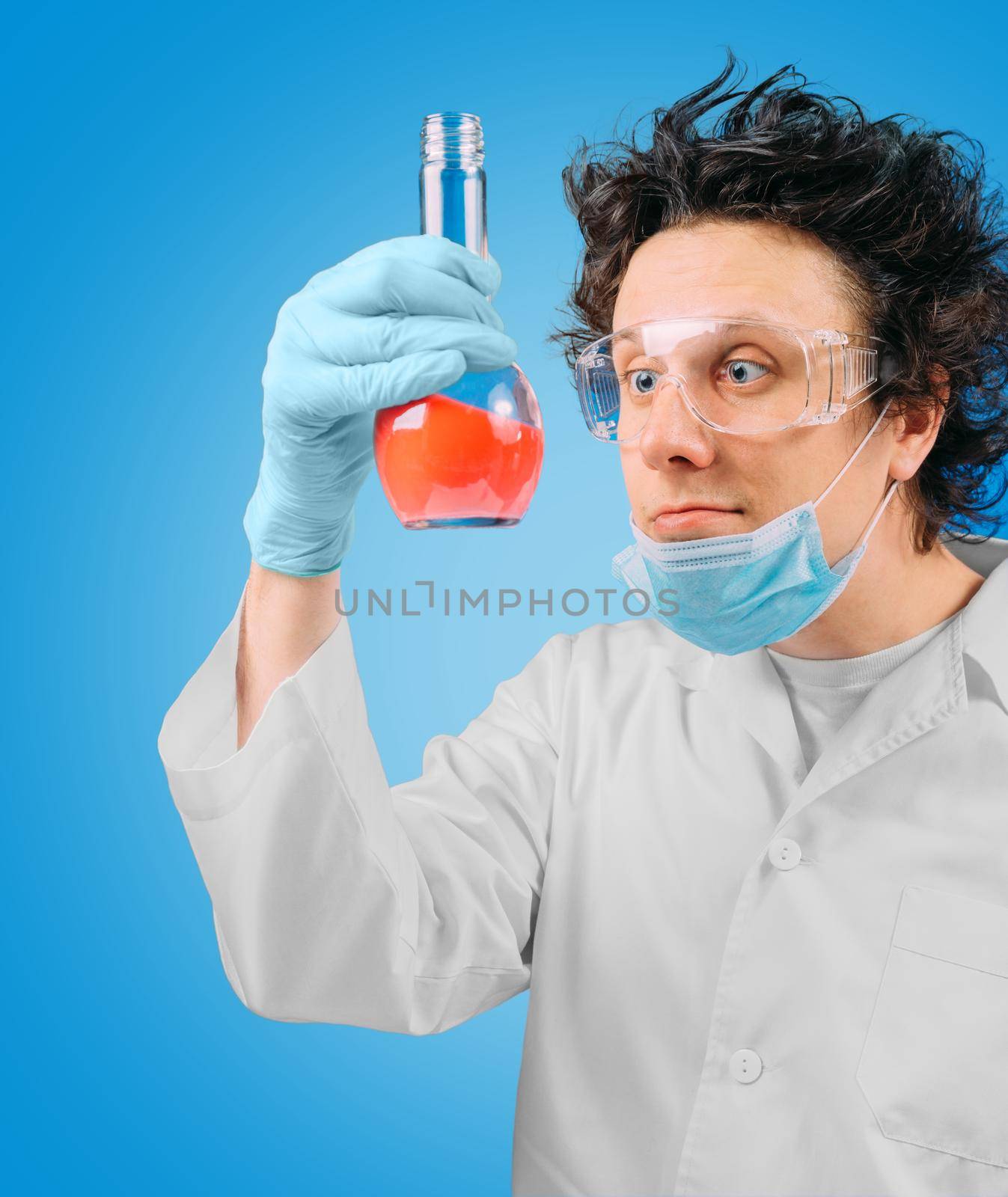 Crazy laboratory technician is looking at test tube with red liquid