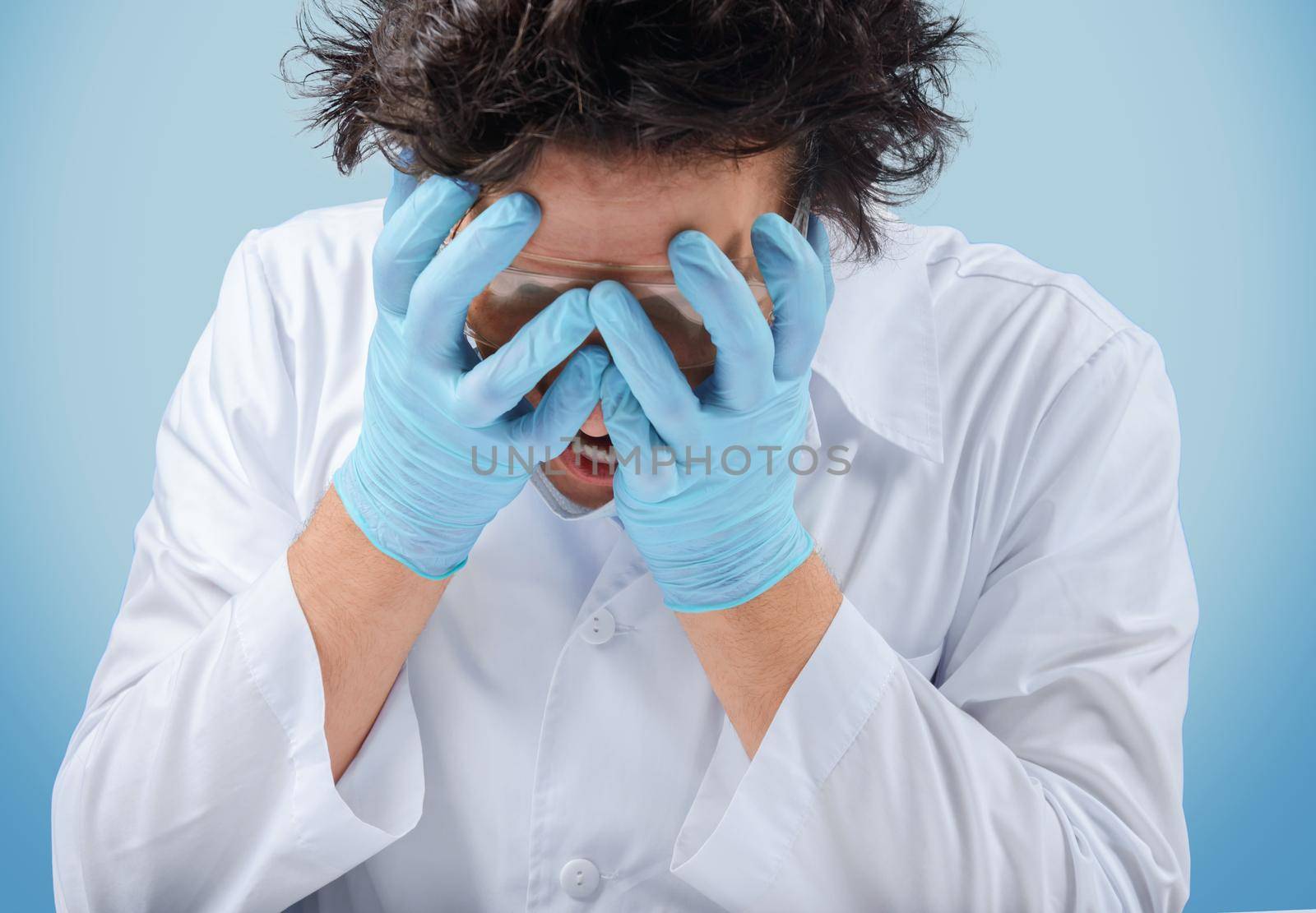 Sad crazy man doctor holds his face