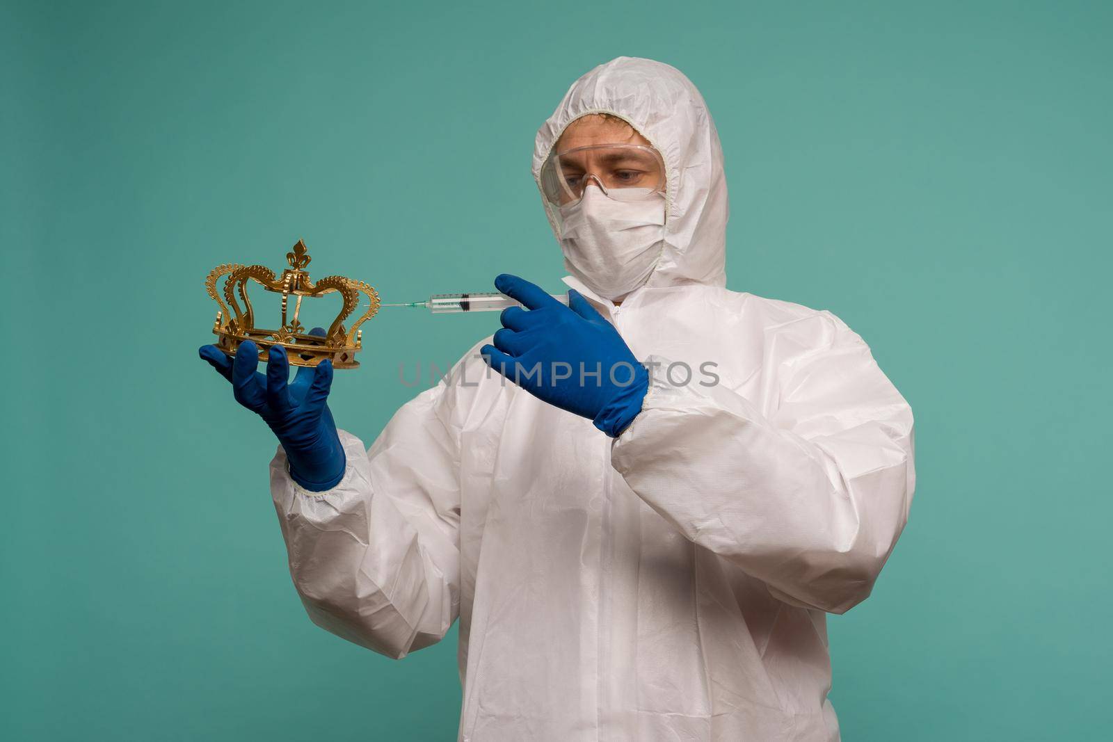 A male doctor in protective overalls and a mask makes an injection in the crown. Coronovirus protection concept in China. - image