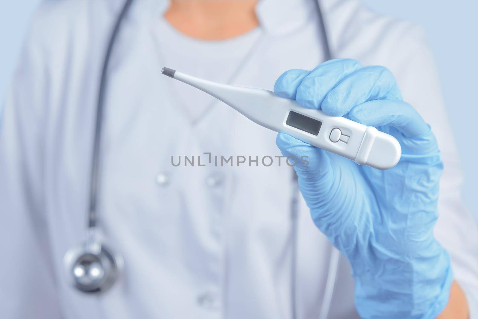 Unrecognizable nurse is showing electron thermometer