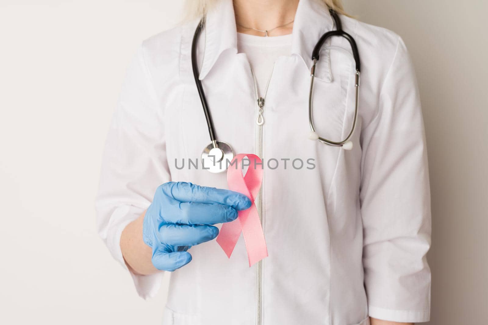 Woman doctor holding a pink ribbon in her hands - image
