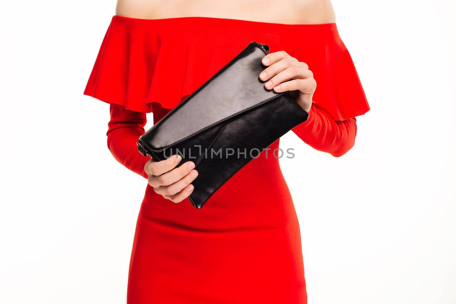 Fashionable woman with a black clutch in her hands and red evening dress on white background