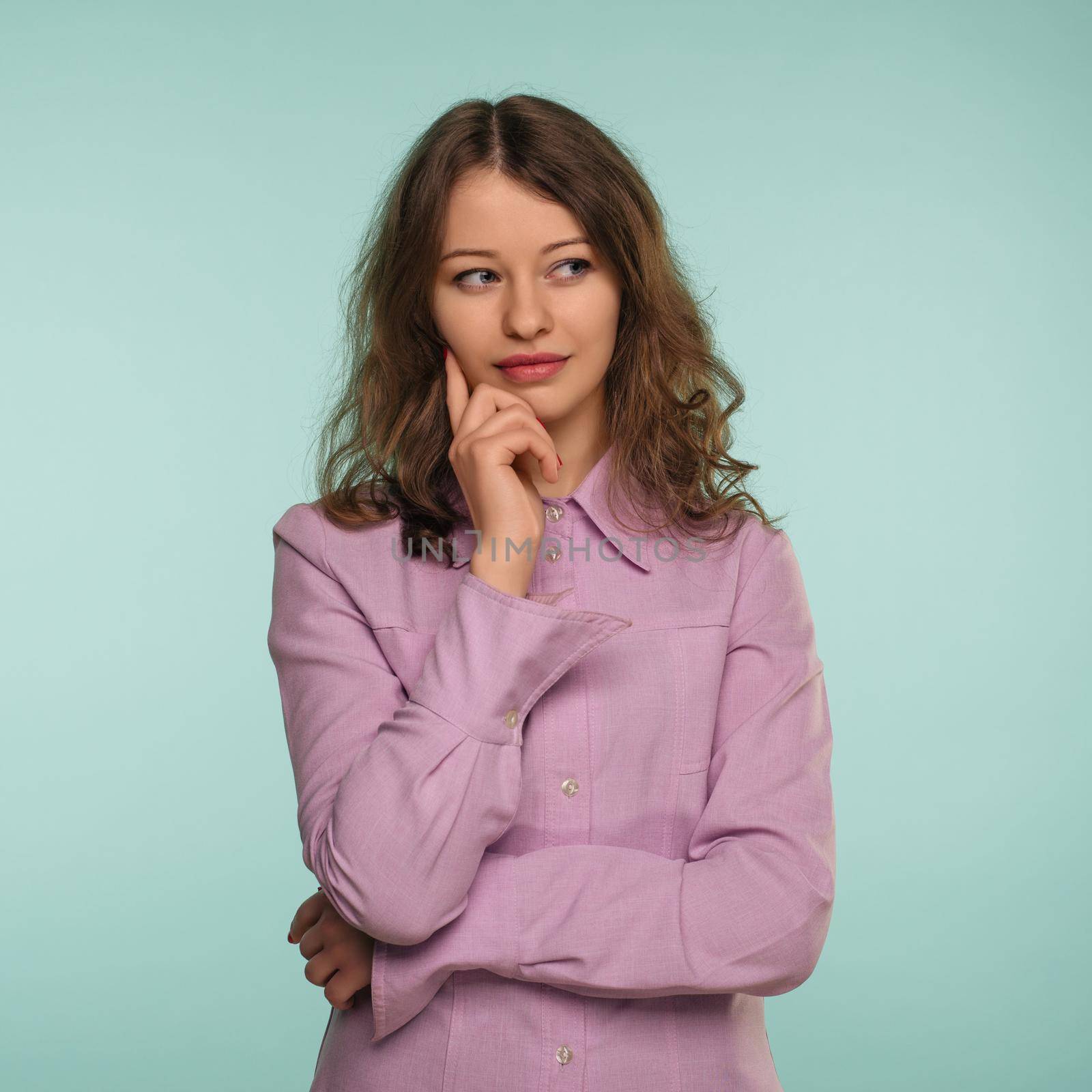 Photo of thoughtful young woman standing isolated over background. Looking aside. - Image