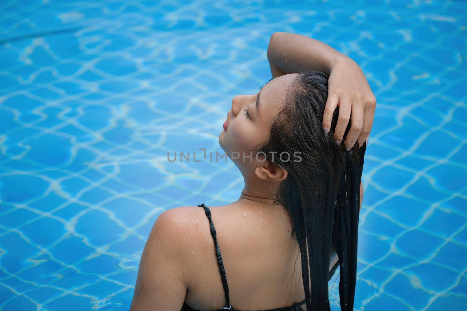Beautiful southeast asia woman in pool relaxing. by Manastrong