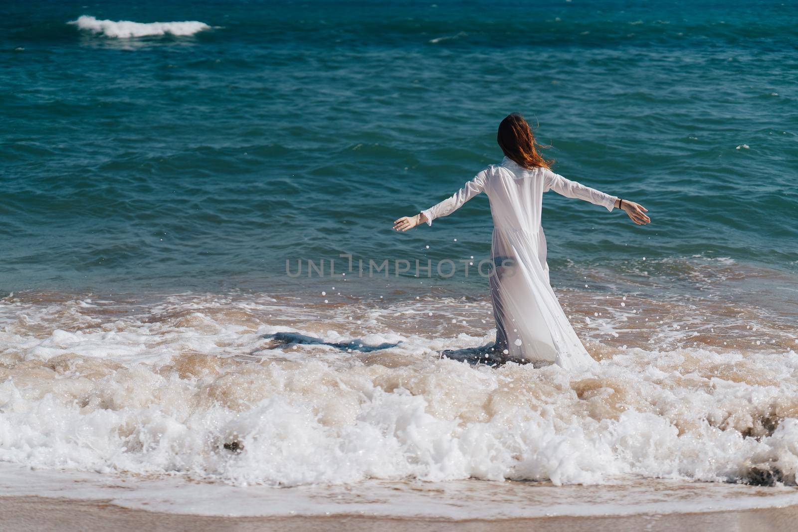 Woman in white dress near the ocean walk fresh air landscape. High quality photo
