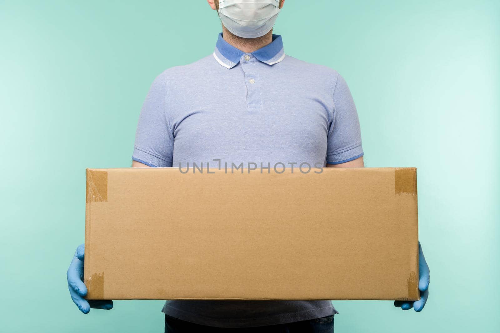 Man holding cardboard boxes in medical rubber gloves and mask. Coronavirus pandemic quarantine delivery concept