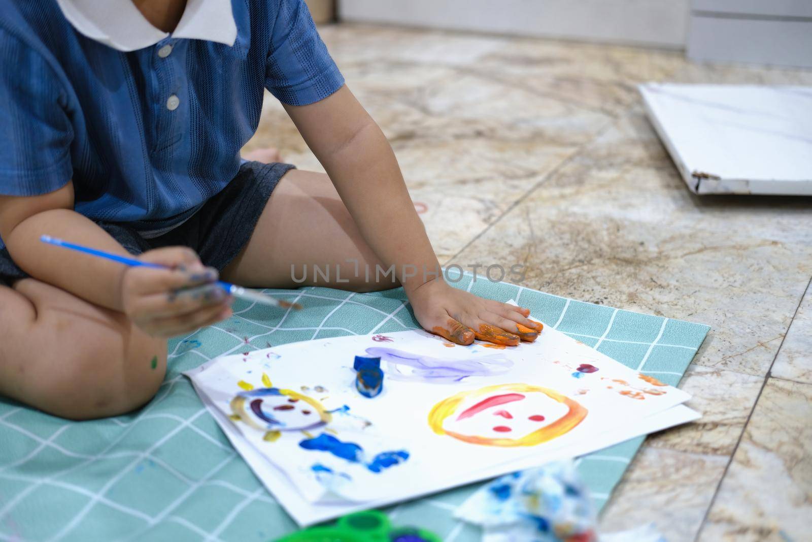 Focus on hands on paper, early childhood learning by using paints and brushes to build imagination and enhance skills on the board. by Manastrong