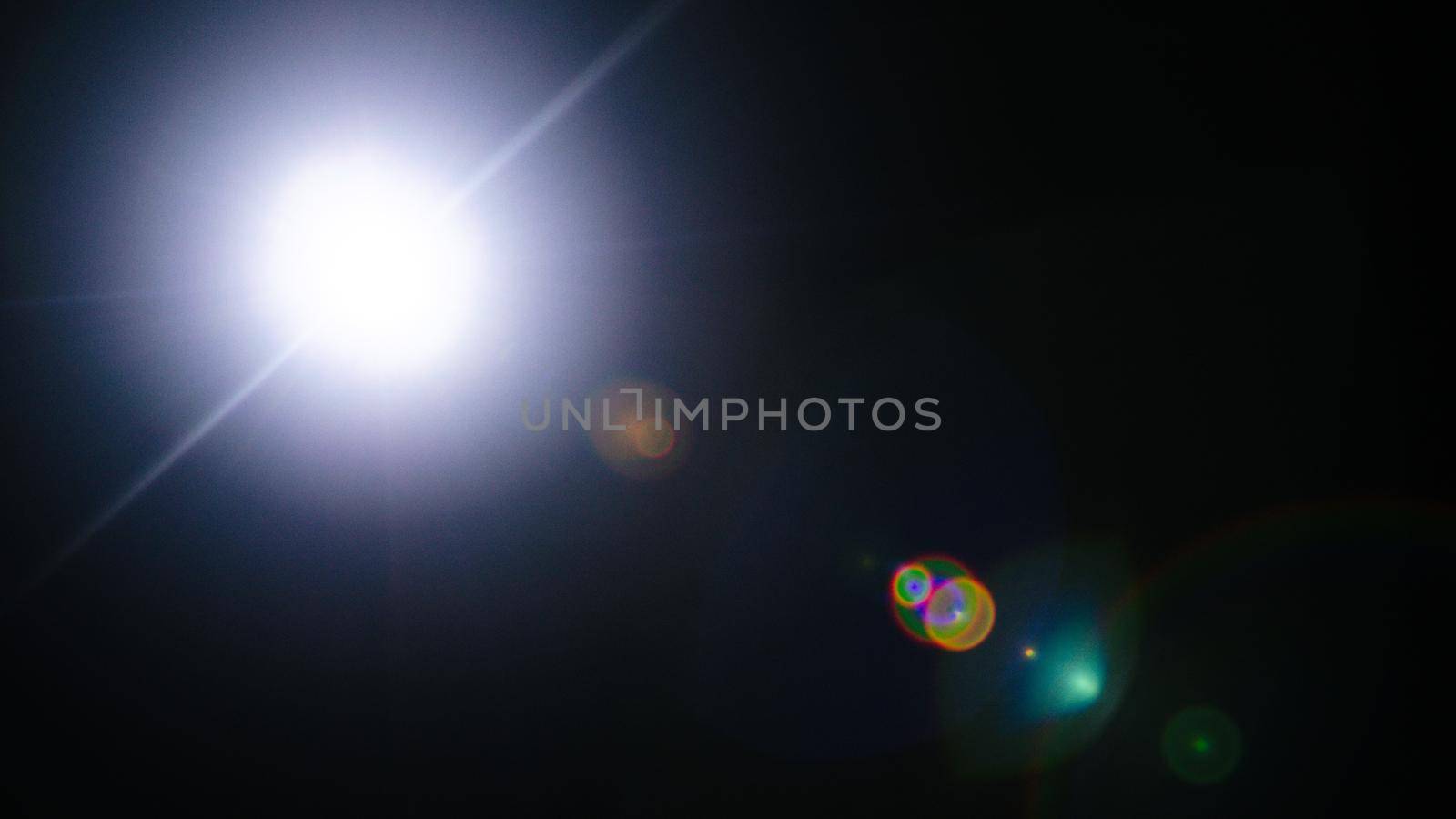 Abstract Natural Sun flare or Far star on the black background - image