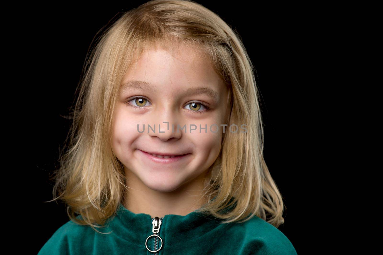Close up view of a cute smiling girl, charming baby, wearing stylish clothes, posing in studio, portrait of a lovely happy girl, isolated on black background