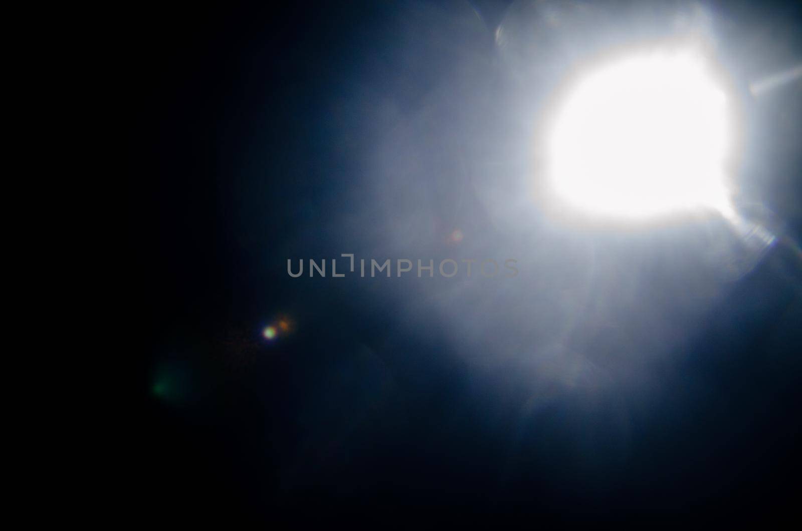 Abstract Natural Sun flare or Far star on the black background - image