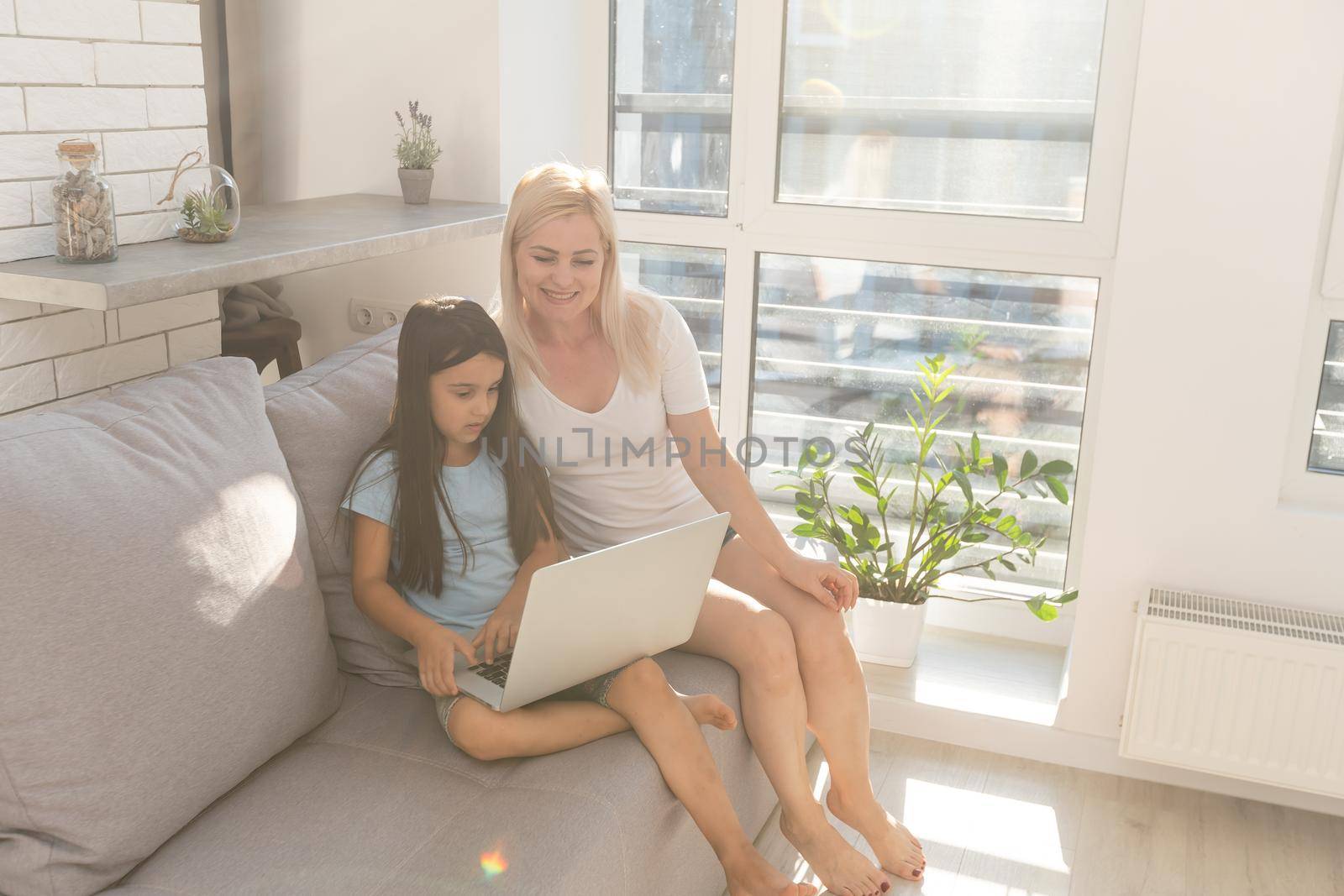 Little girl studying online using her laptop at home by Andelov13