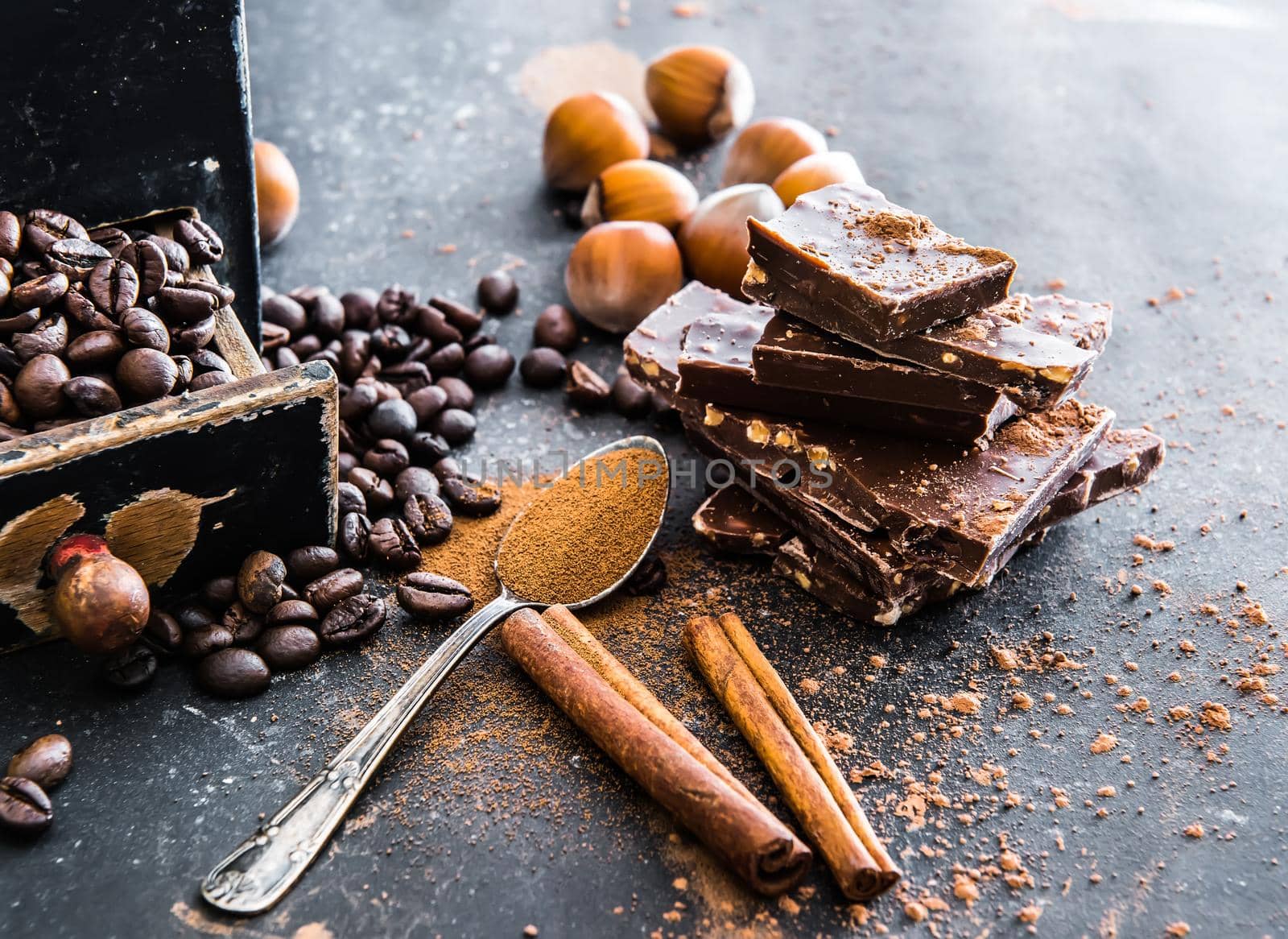 Chocolate, nuts, spices on a smooth black table