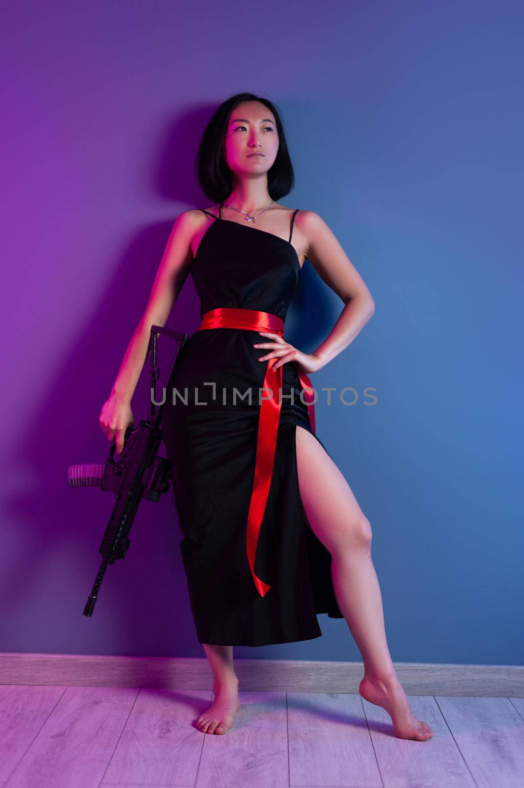 asian woman with a machine gun aims for shooting by Rotozey