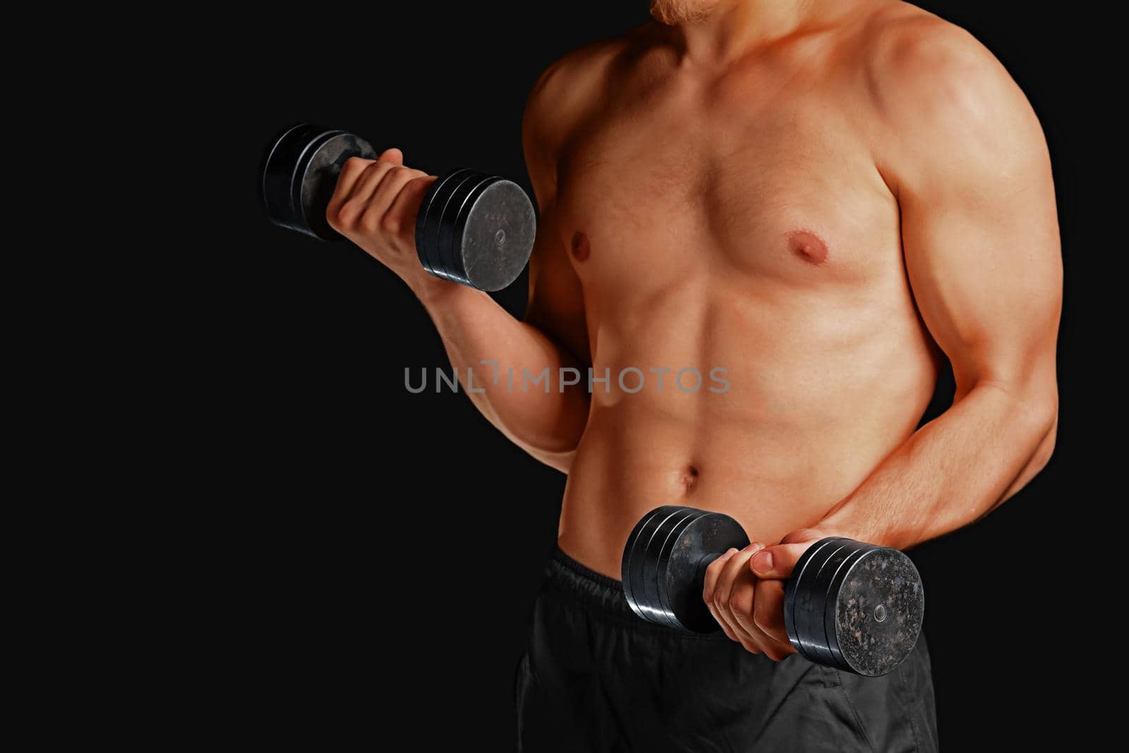 Unrecognizable muscular man exercises with metal dumbbells