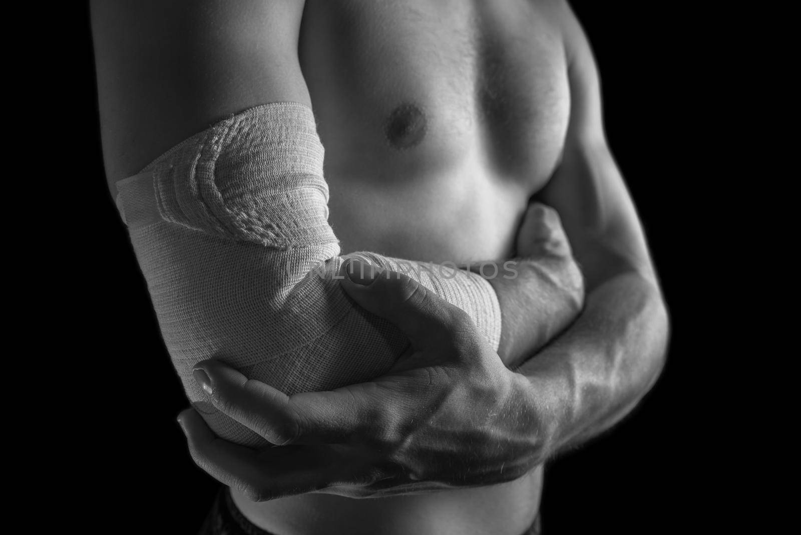 Man holds his elbow joint, acute pain in the elbow, monochrome image