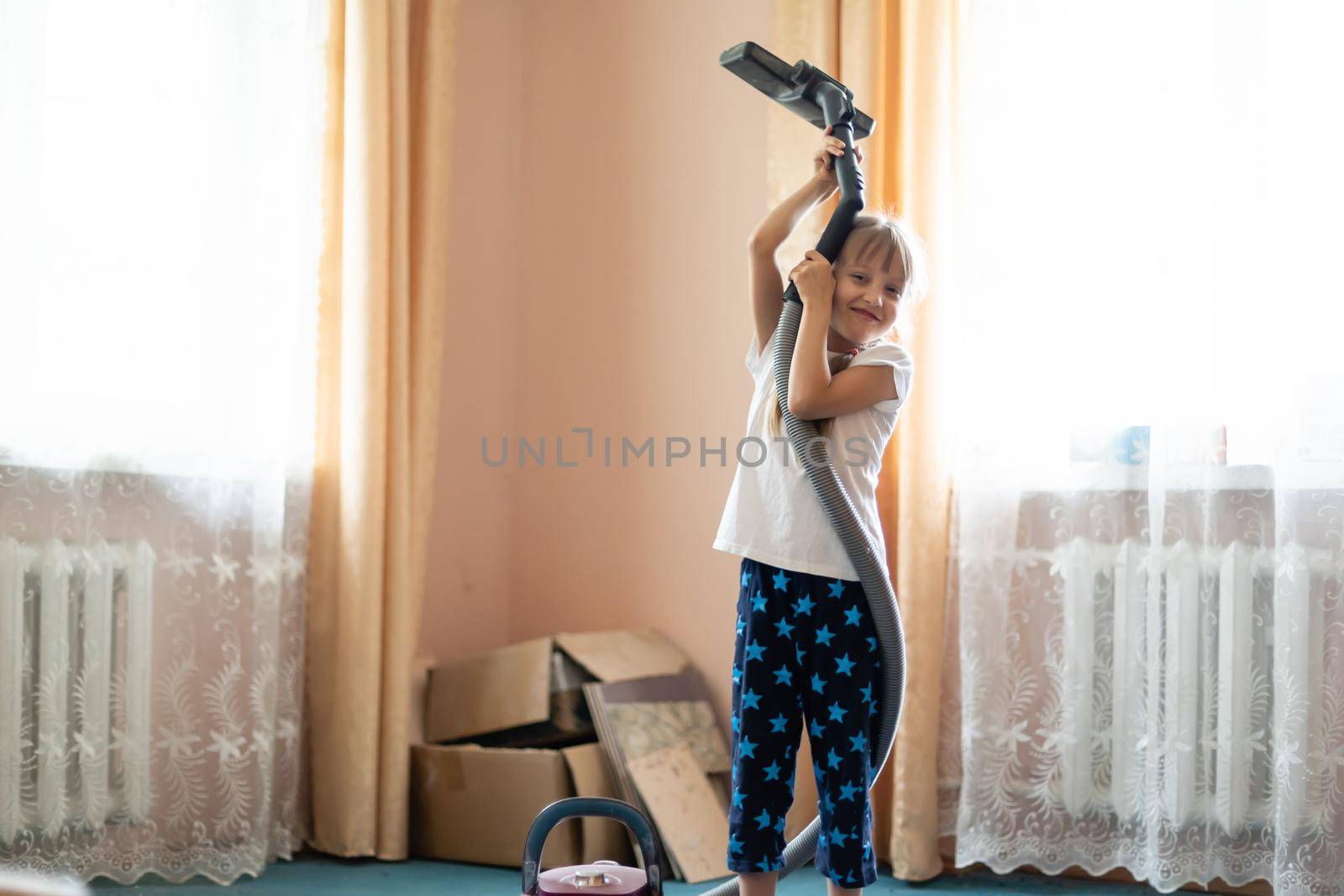 Little girl cleaning floor with vacuum cleaner by Andelov13