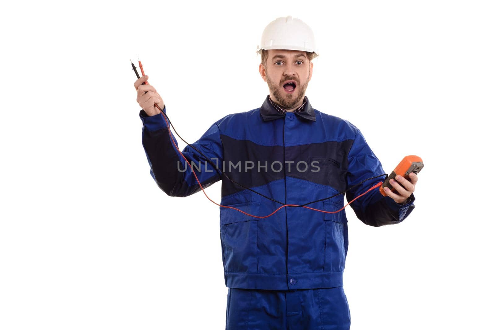 surprised electrician engineer in helmet and uniform with tester instrument in hands isolated on white background