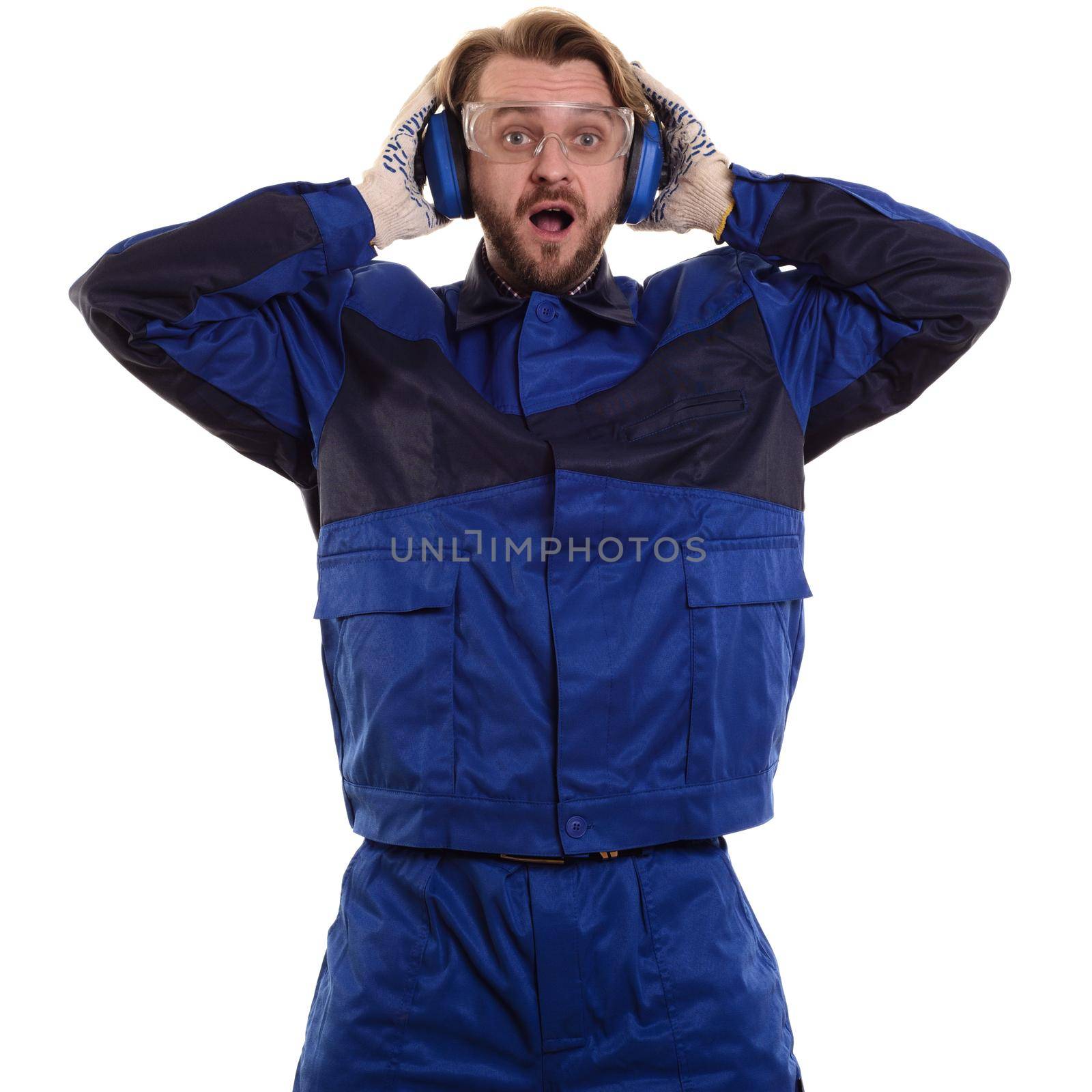 Surprised worker in glasses is standing with his mouth holding his safety headphones by zartarn