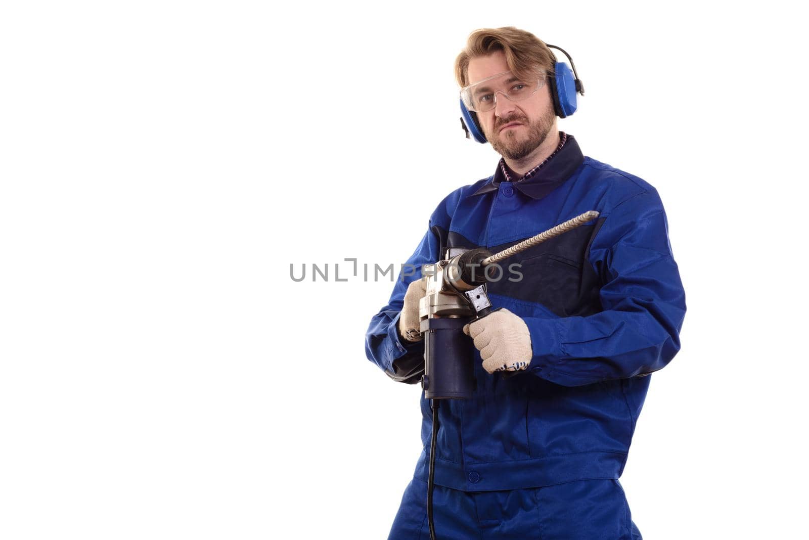 Construction worker in protective glasses and headphones with a puncher on a white background.